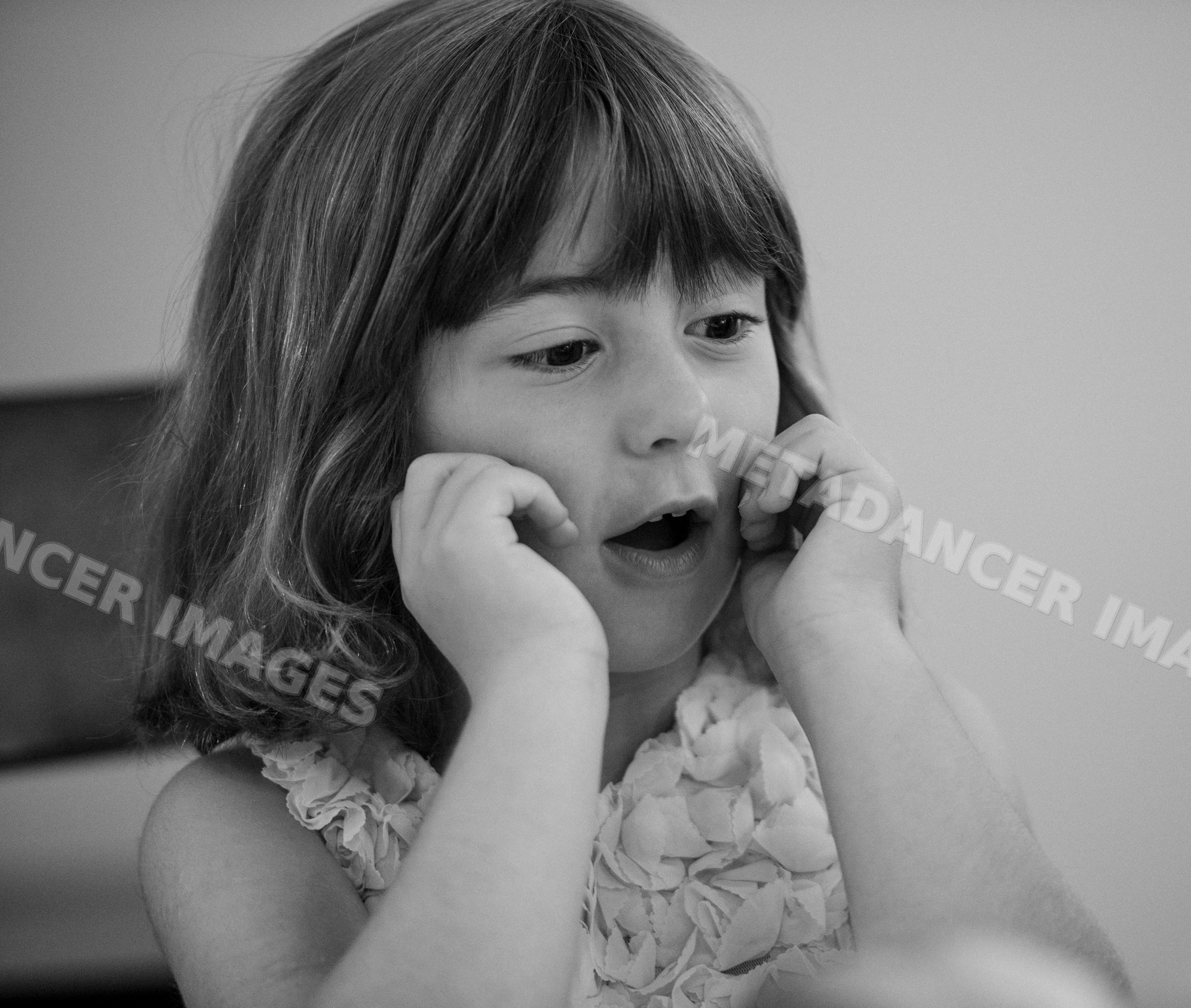 Young white girl expressing surprise with hands on her face