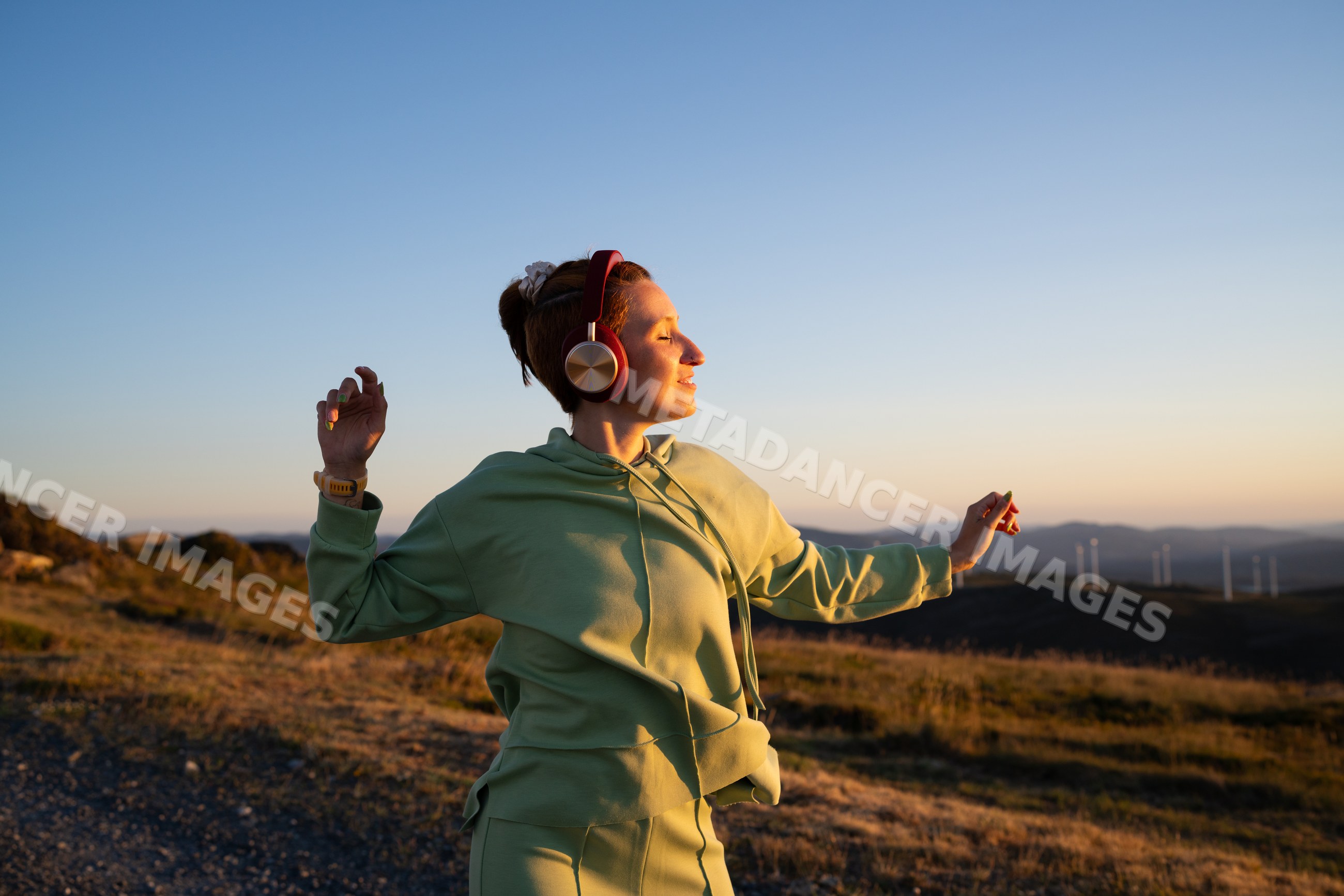 White Woman enjoying music and dancing outdoors at sunset in Galicia