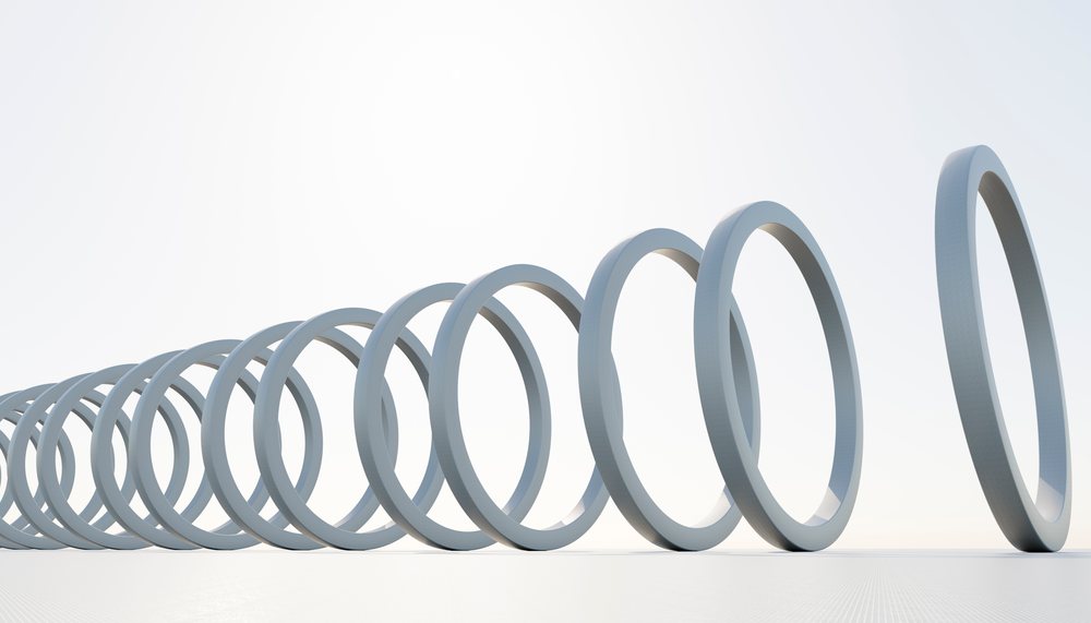 White rings arranged in a falling domino effect on a plain white