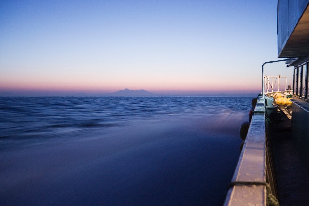 Sunset over nemuro channel from boat side railing, Japan