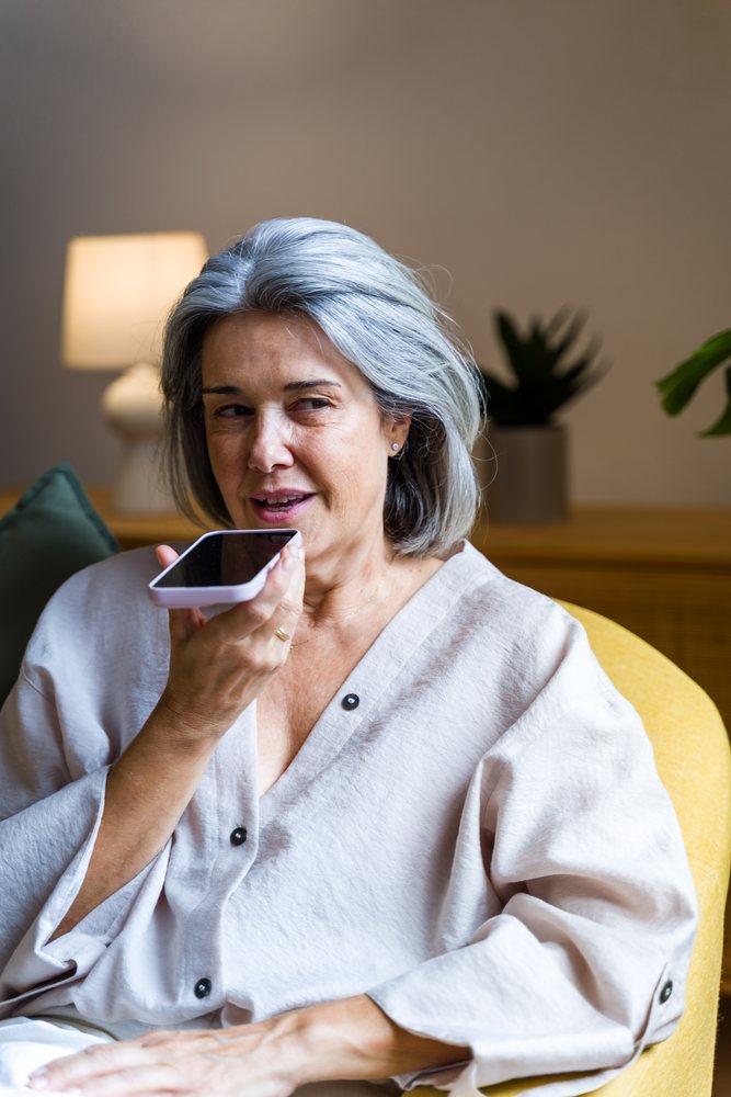 Mature white woman talking on smartphone indoors sitting