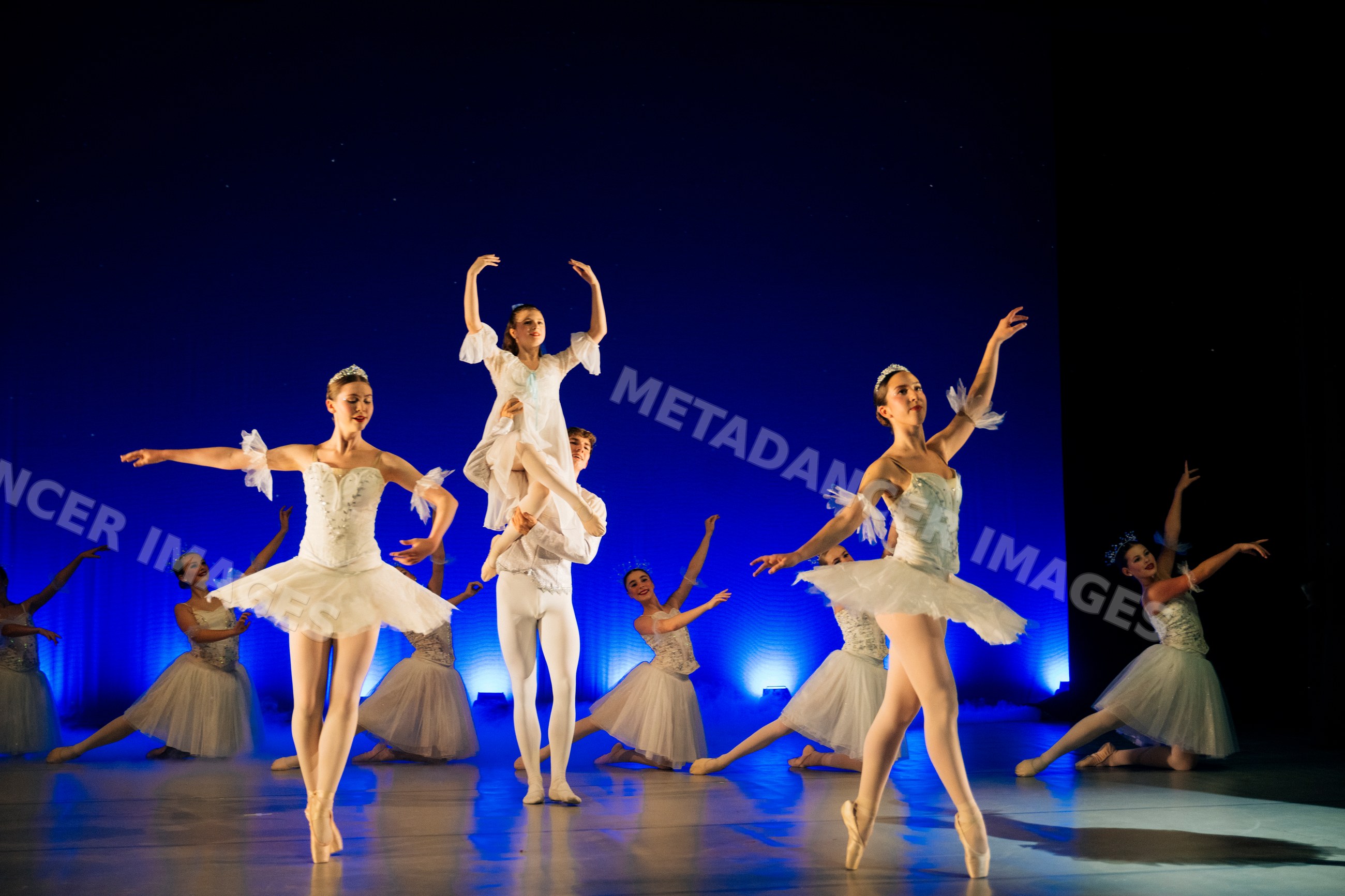 Ballet dancers perform a classical lift and dance routine on stage