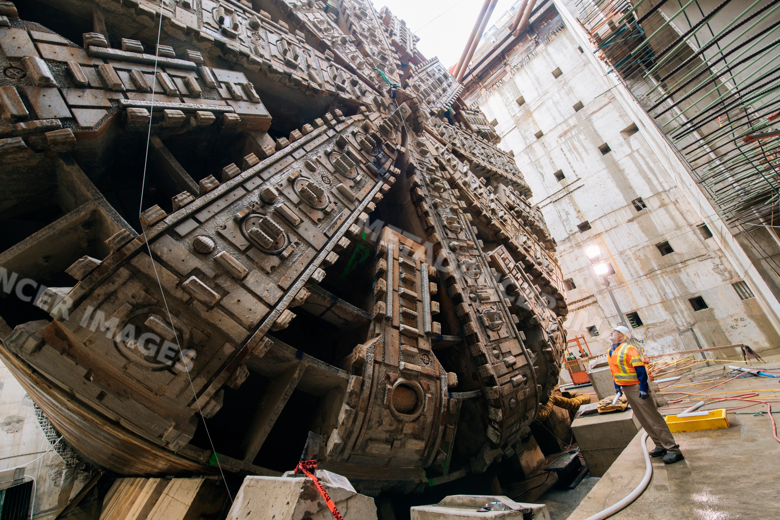 Construction white workers inspect massive tunnel boring machine