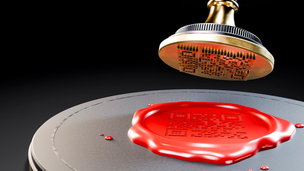 Red wax seal being stamped with embossed pattern on metal surface