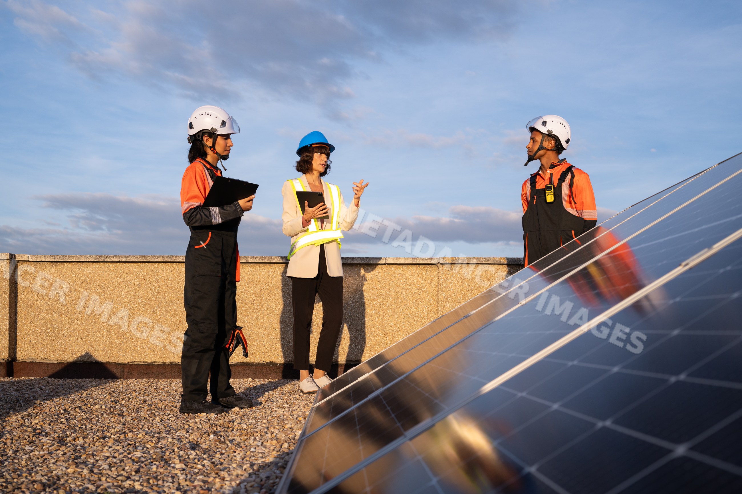 Engineers inspecting solar panels on a rooftop in Madrid, Spain