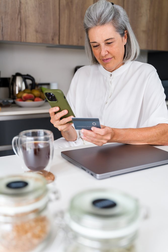White Woman using phone and credit card for online shopping