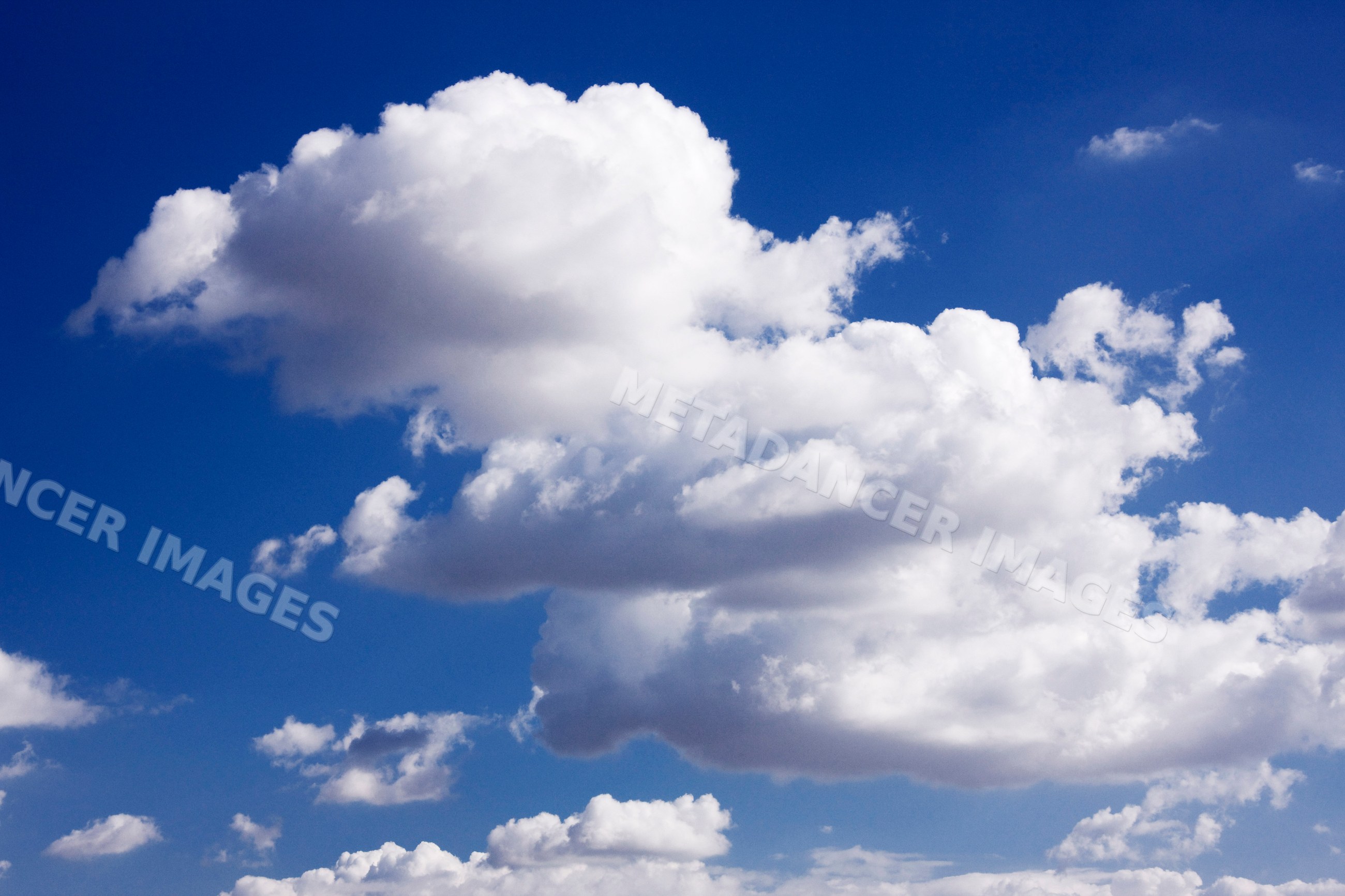 Fluffy white clouds in a clear blue sky