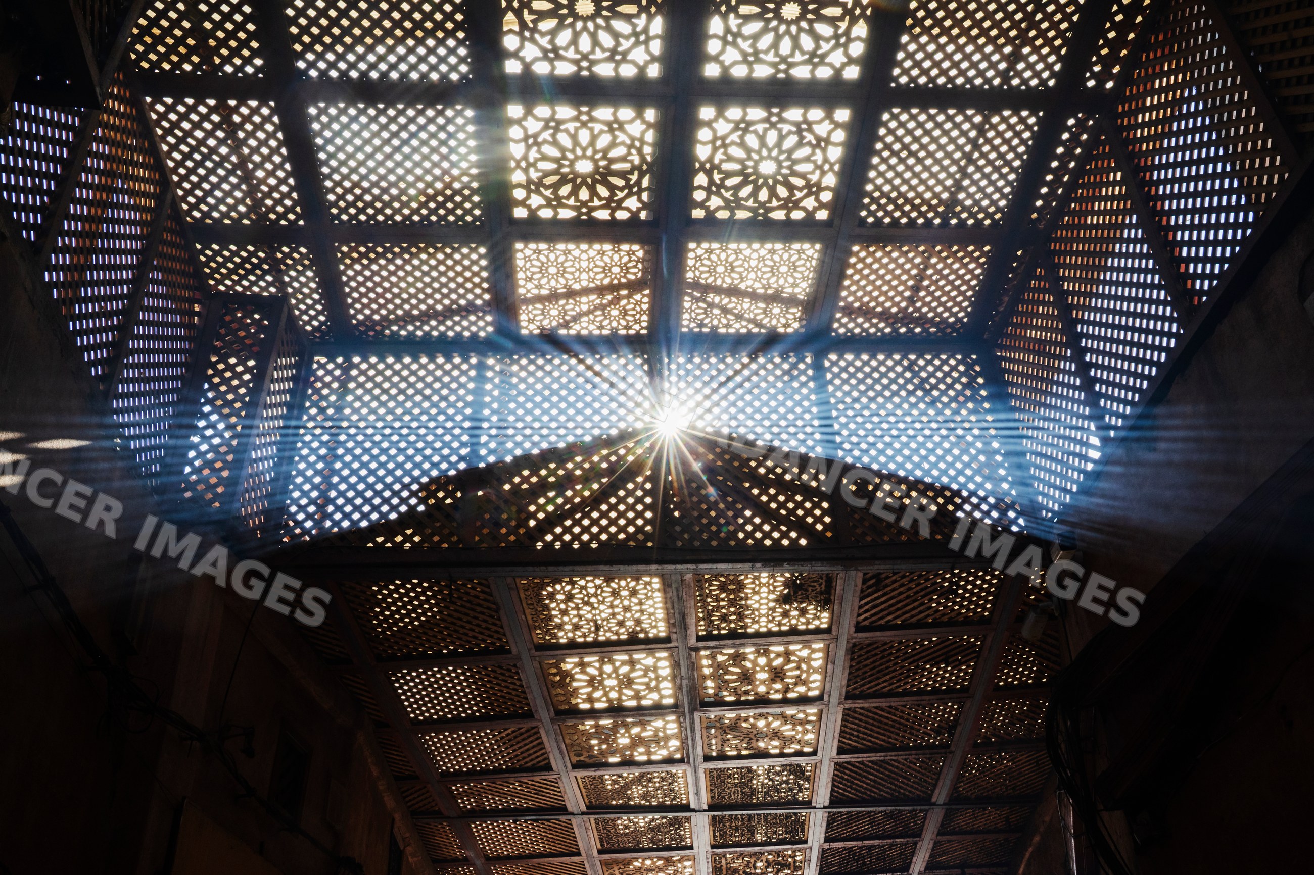 Sunbeams shining through latticework ceiling in the souk