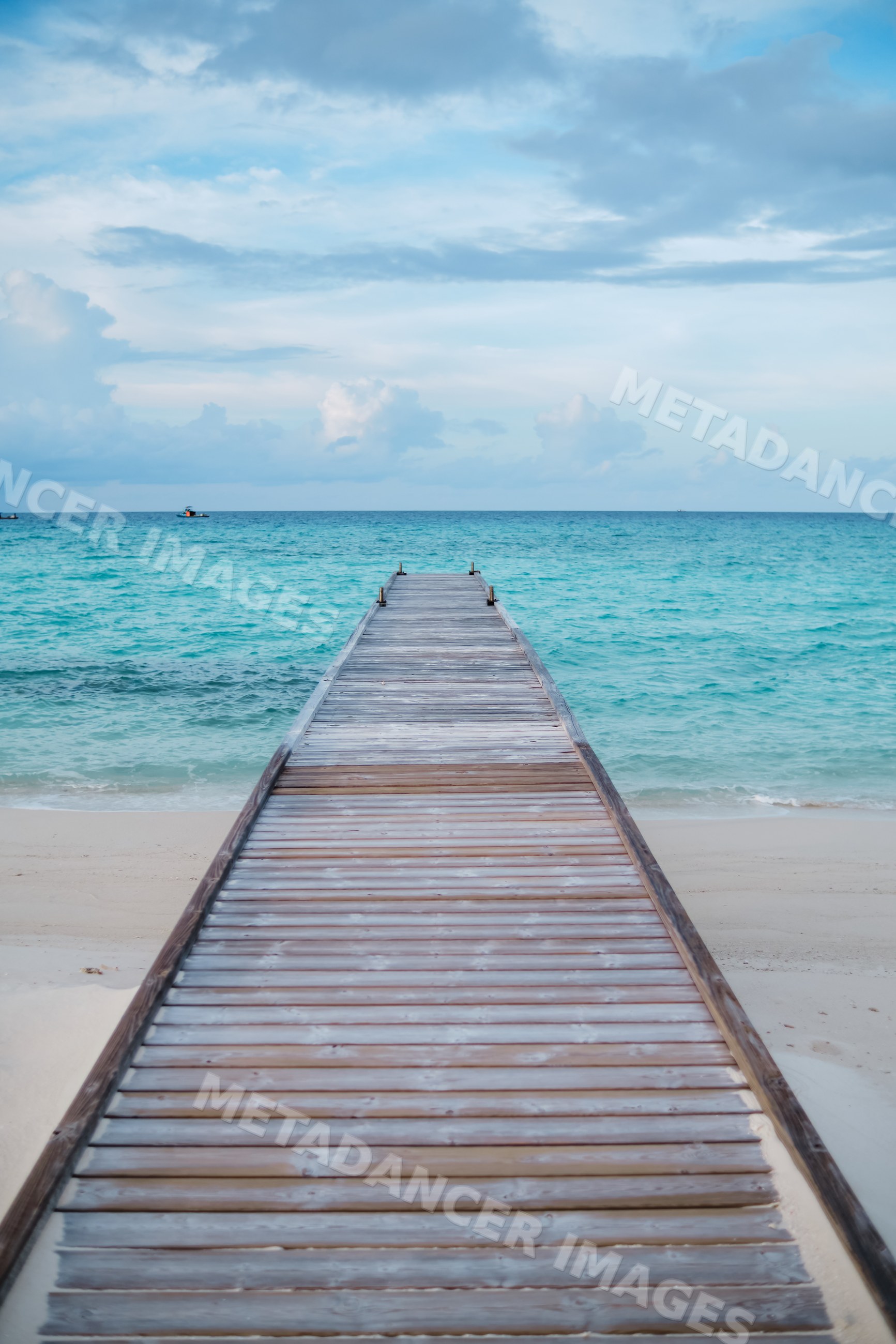 A wooden pier stretches over turquoise ocean waters