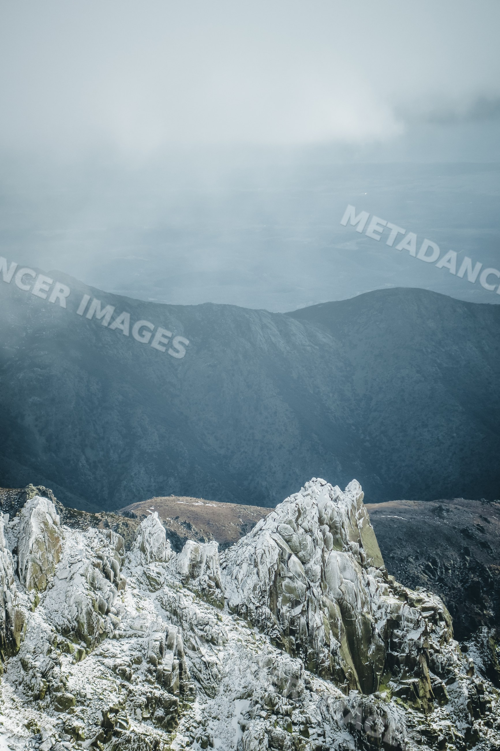 Snowy rocky mountain peaks with fog in Spain landscape