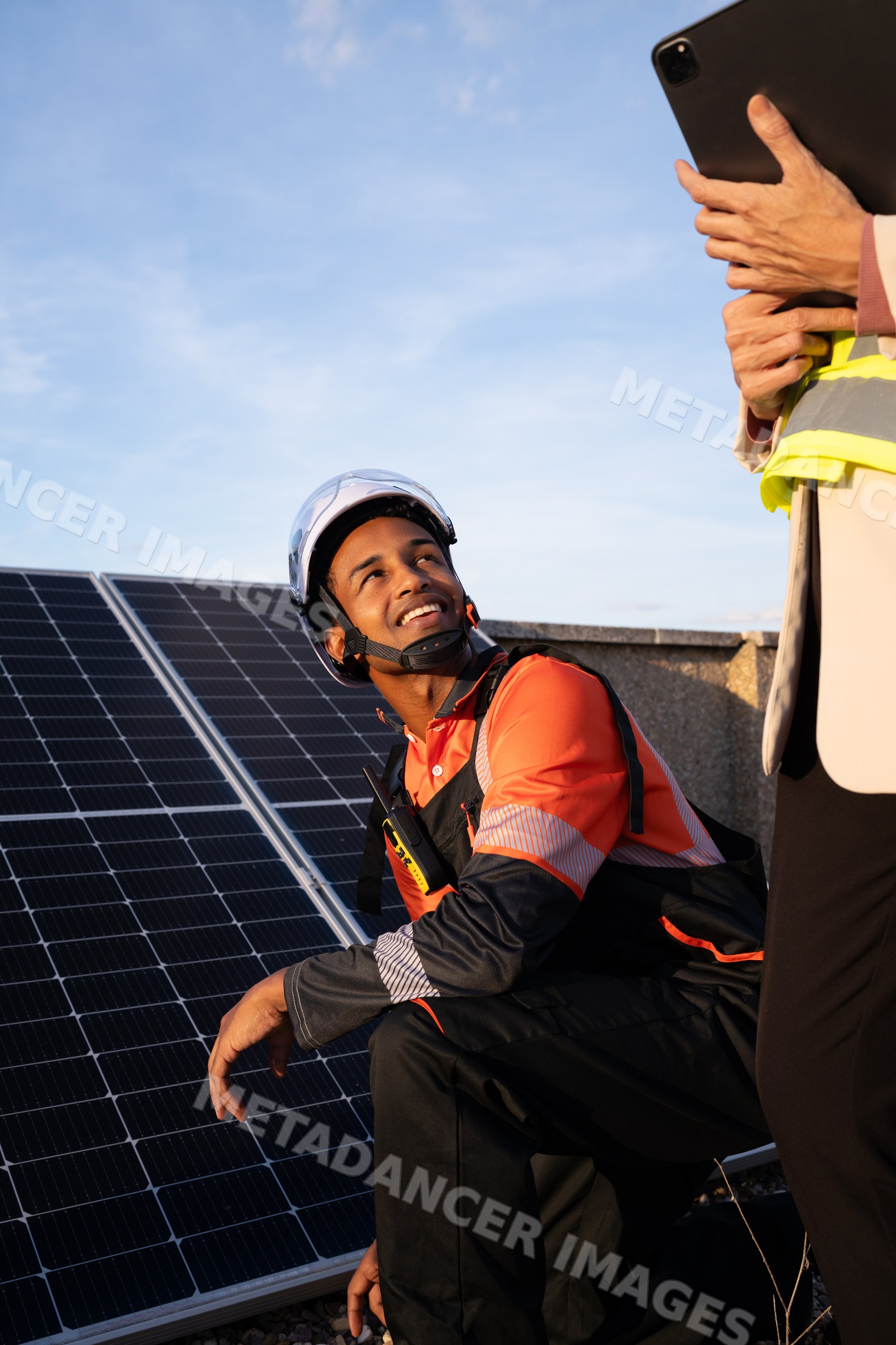 White worker inspecting solar panels on rooftop