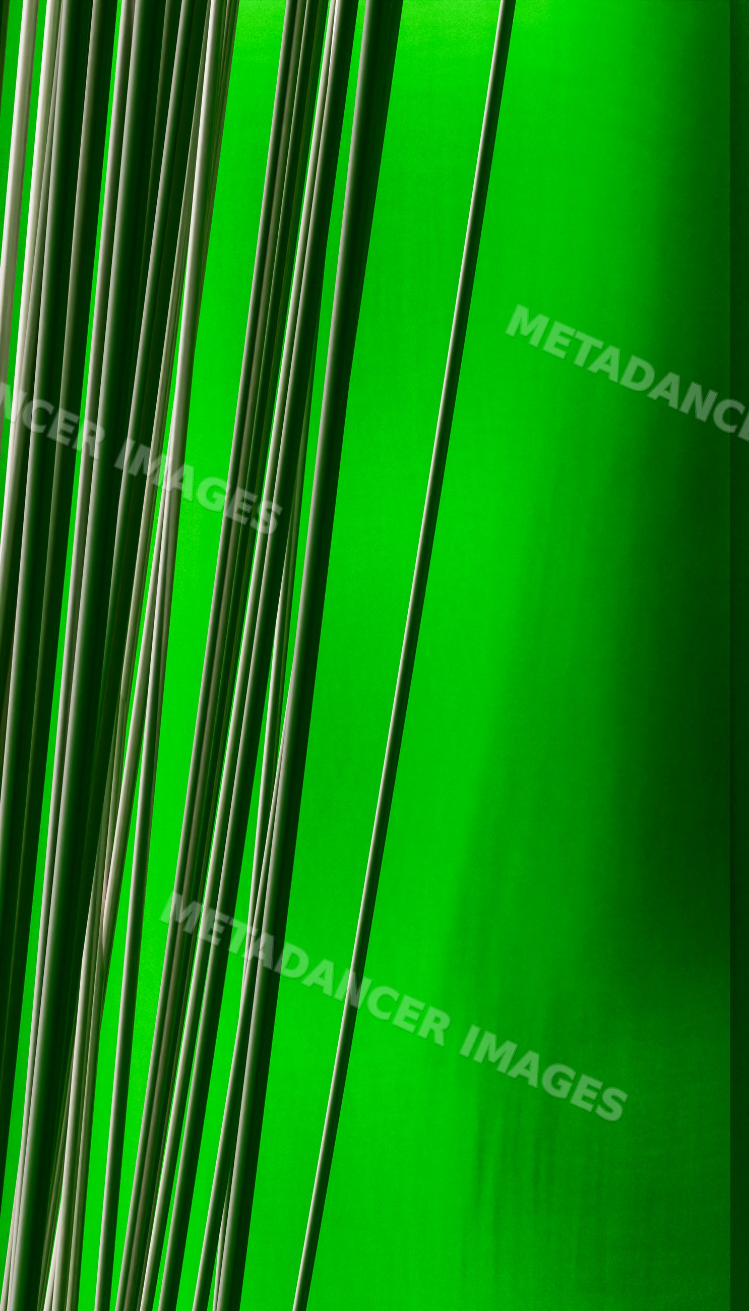 Closeup of vertical rods with striped pattern on green background