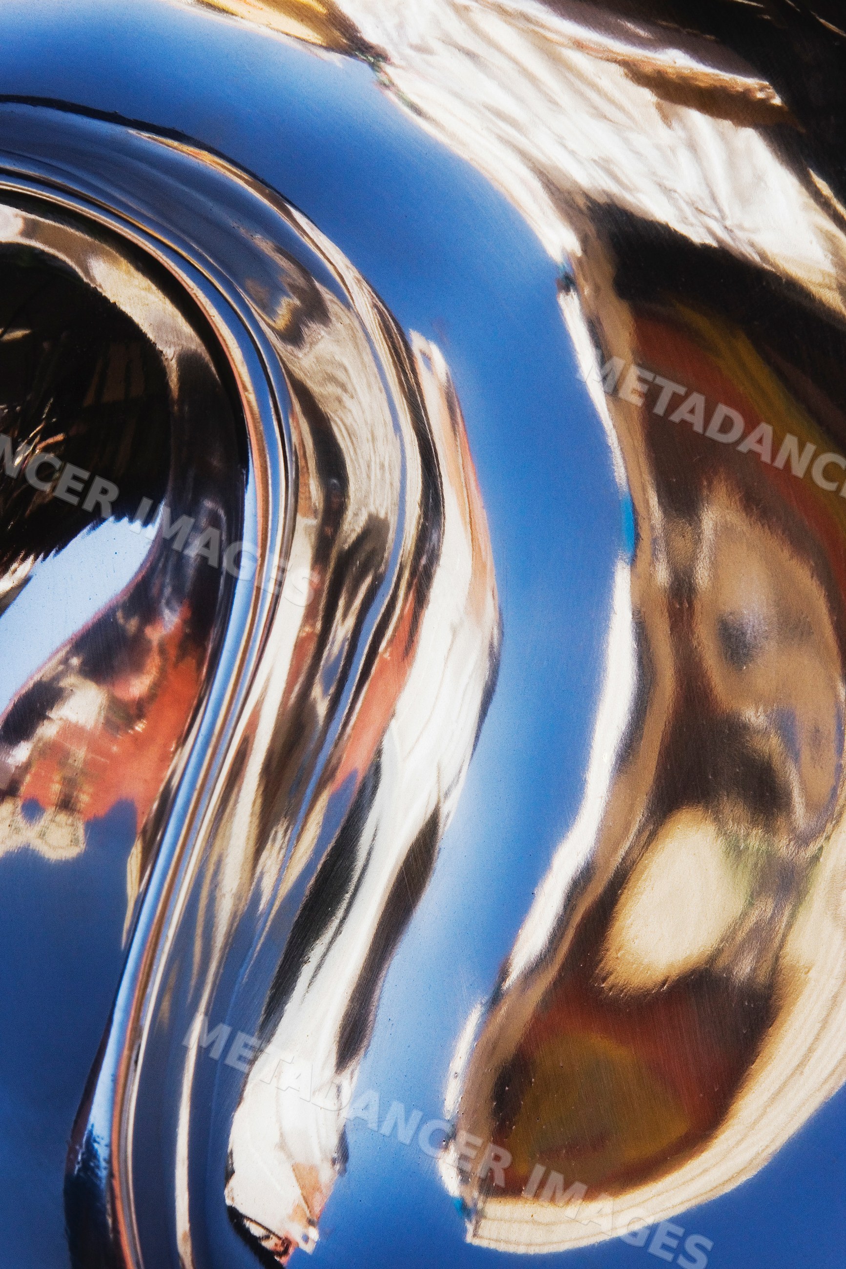 Abstract distorted reflection on shiny curved metal surface