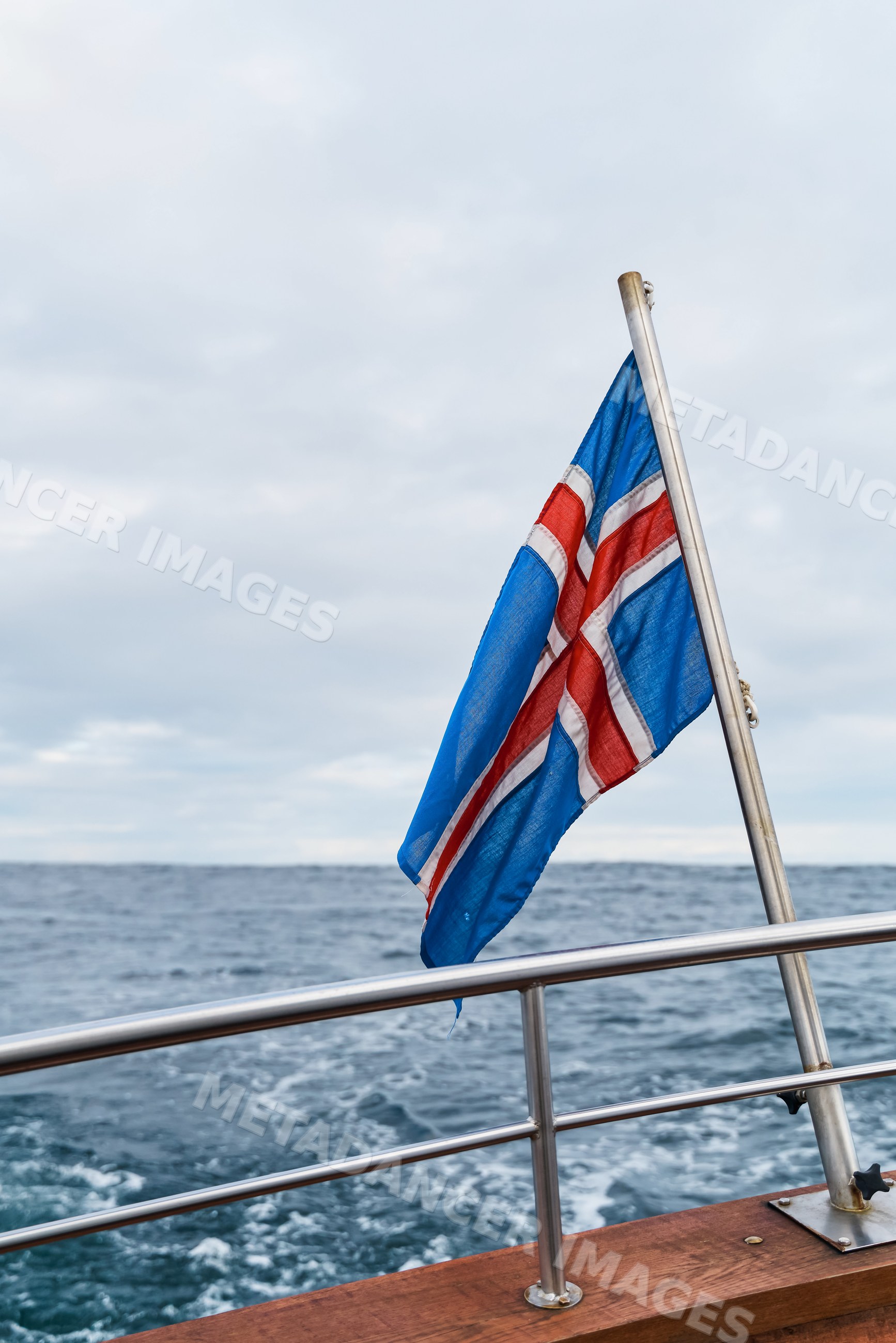 A flag fluttering on a boat at sea in Iceland