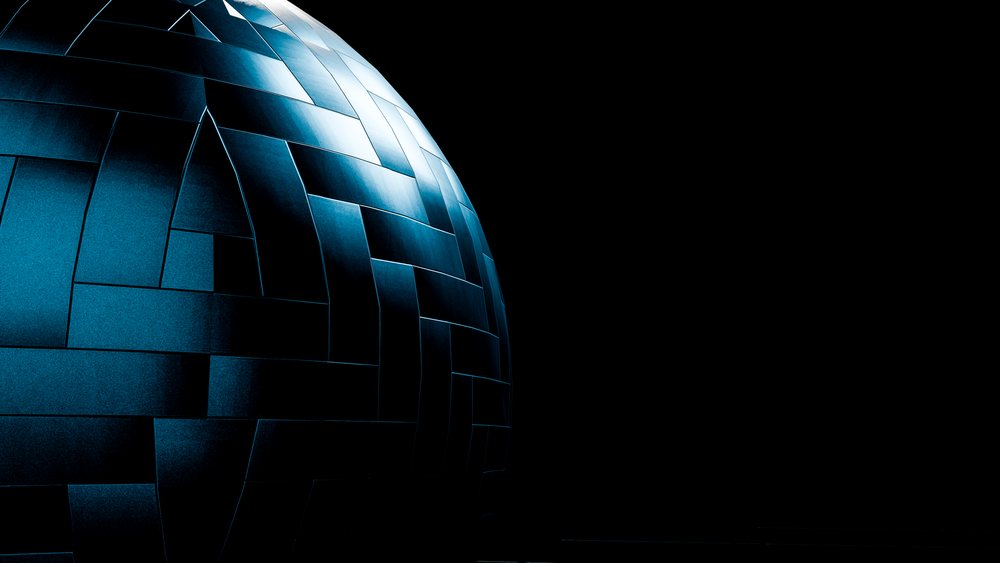 Metal sphere with geometric panels lit by blue light against dark