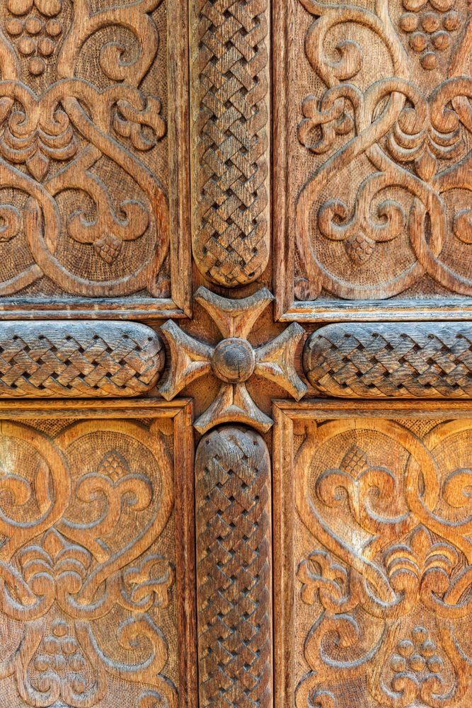 Ornate carved wooden door with cross