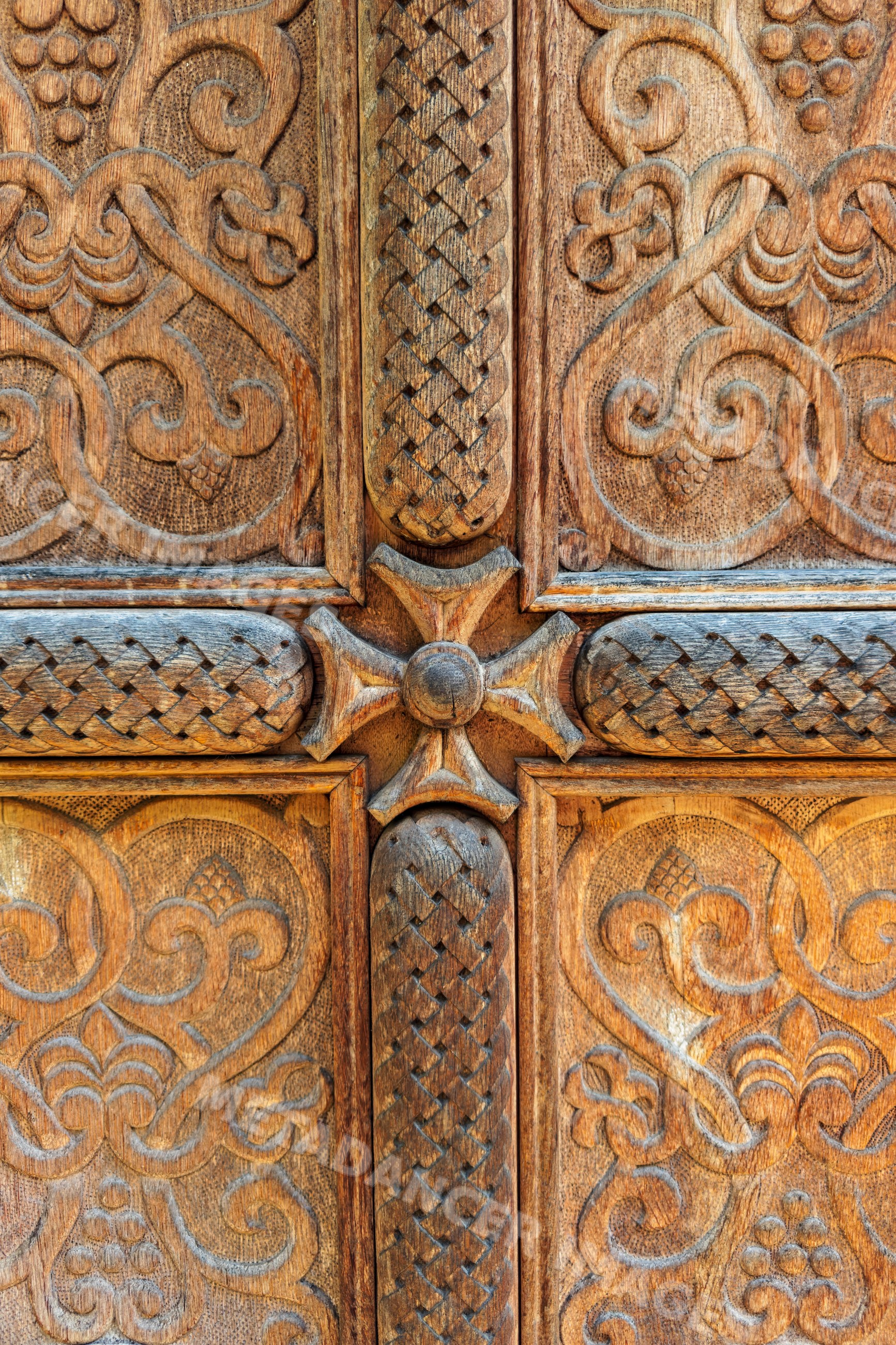 Ornate carved wooden door with cross