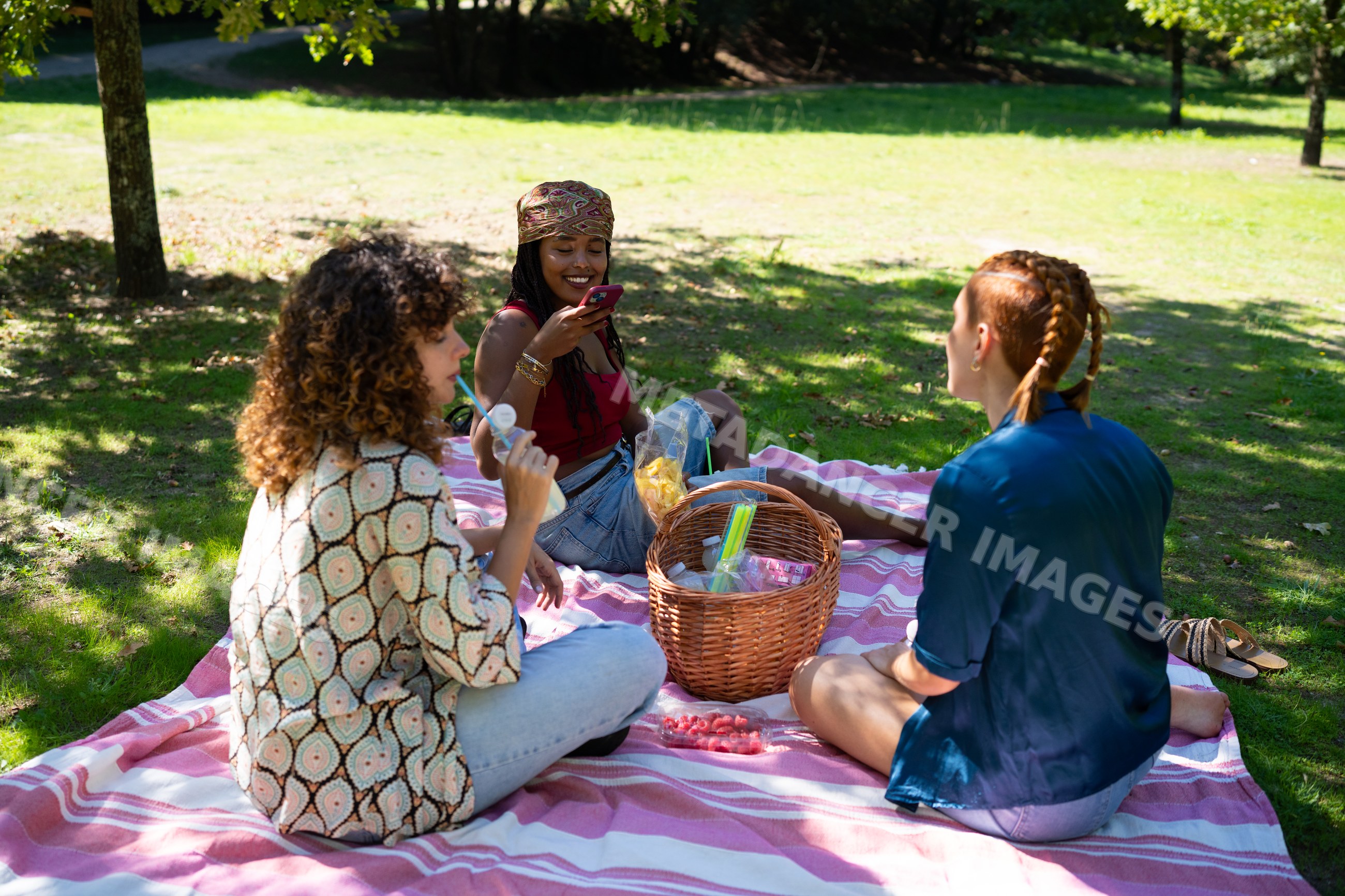 White and African American women enjoying a picnic with snacks