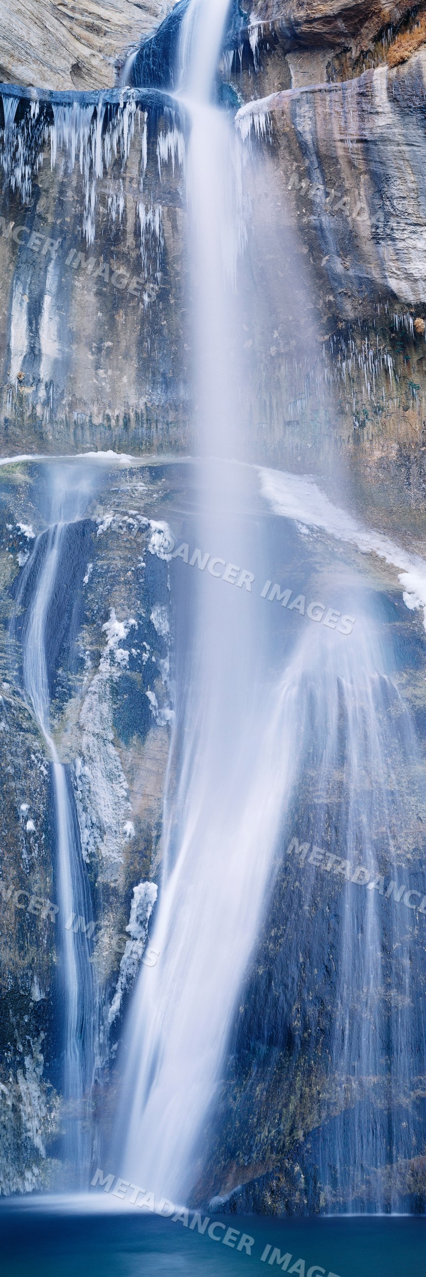 Lower calf creek falls waterfall with icicles in utah