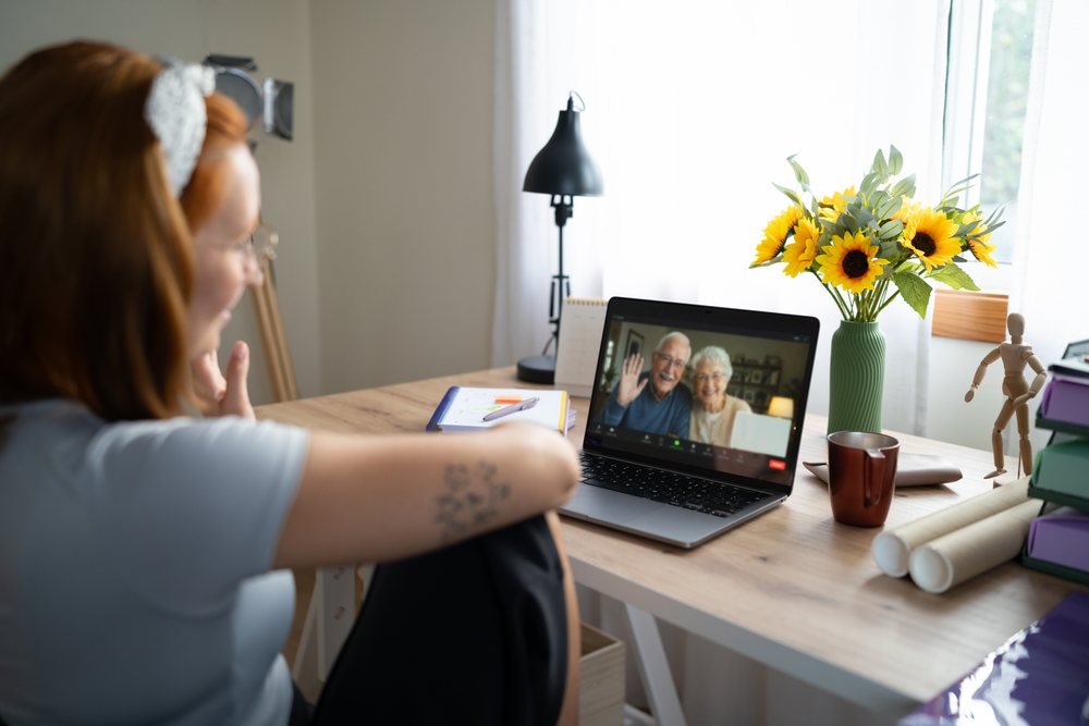 A young white woman video calls an older couple