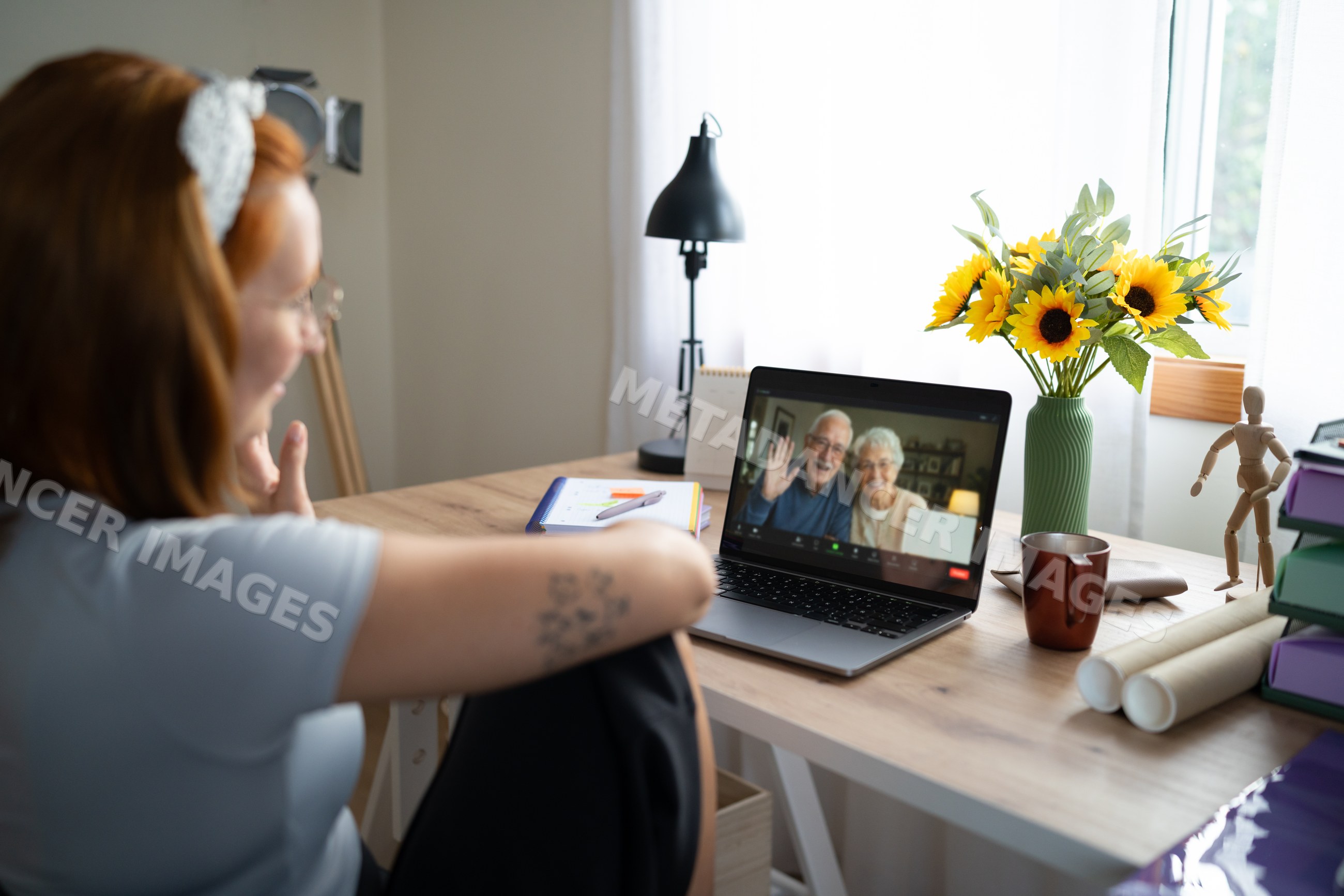 A young white woman video calls an older couple