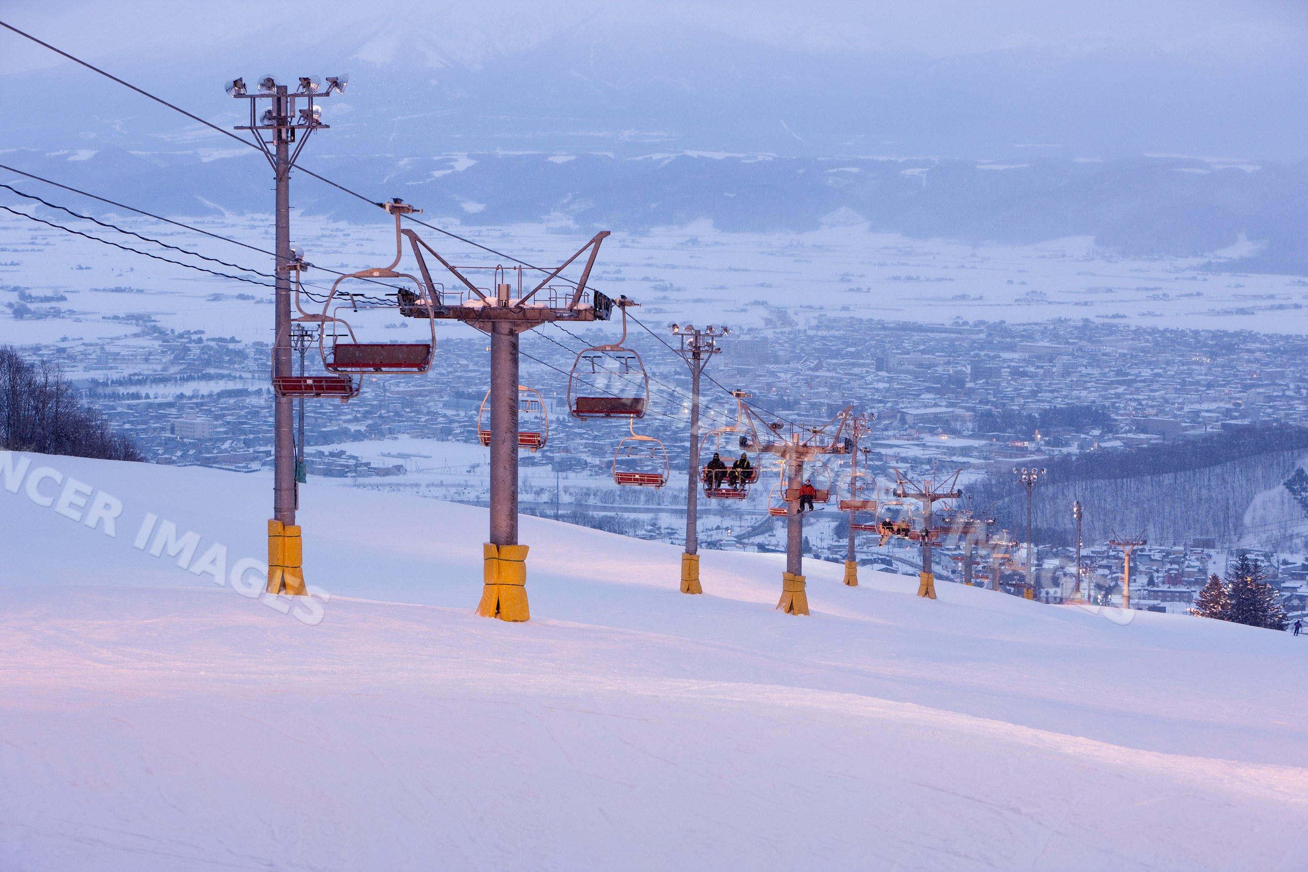 Ski lift carrying skiers up snowy slope hokkaido japan