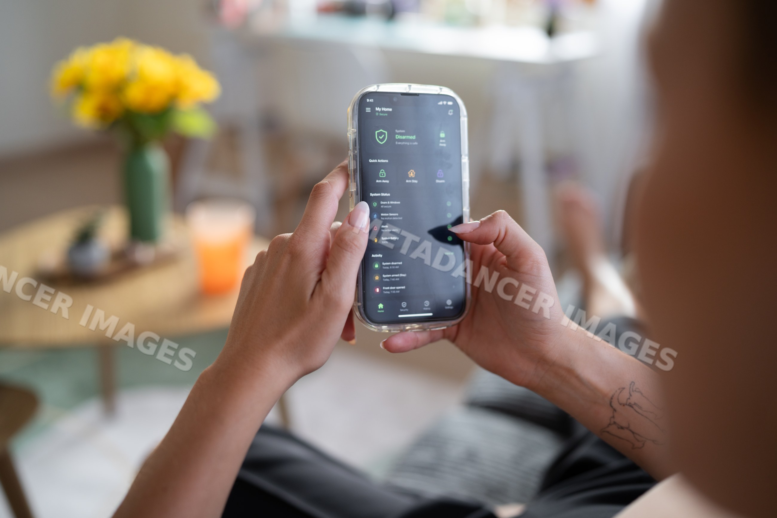 White Person monitors home security system remotely using smartphone