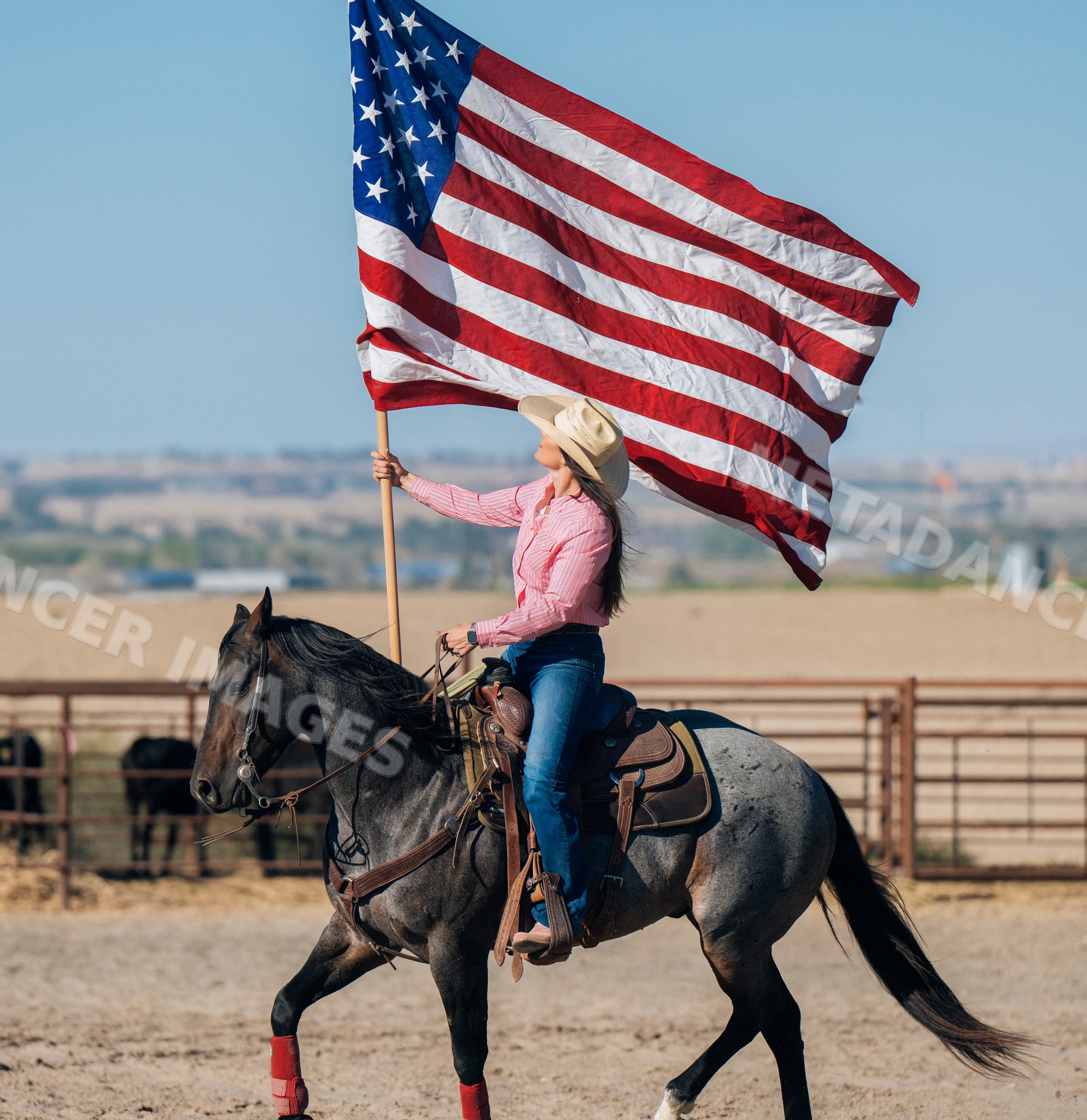 White woman riding horse waving american flag