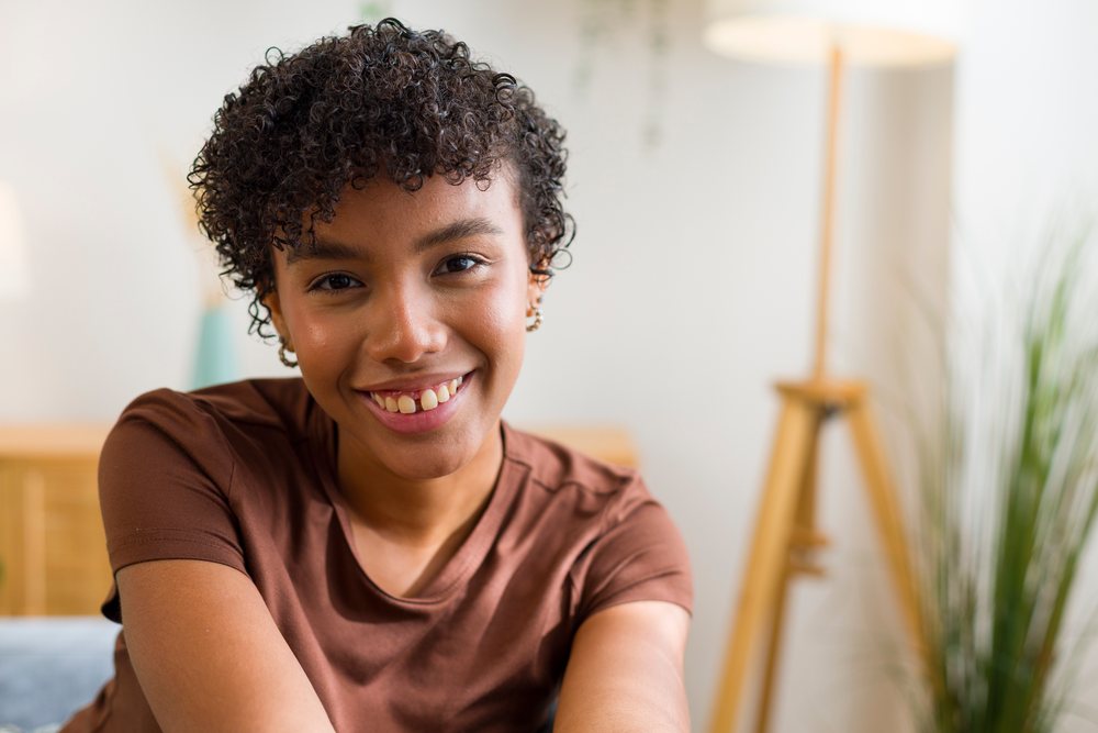 Young African American woman smiling indoors in home living room