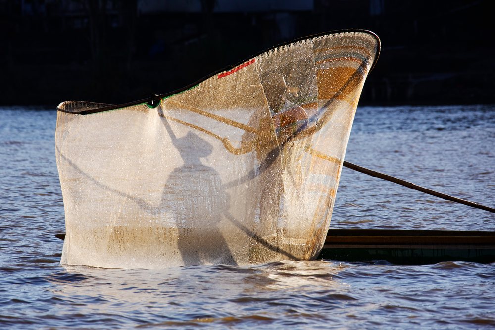 Fishermen casting net on lake mexico