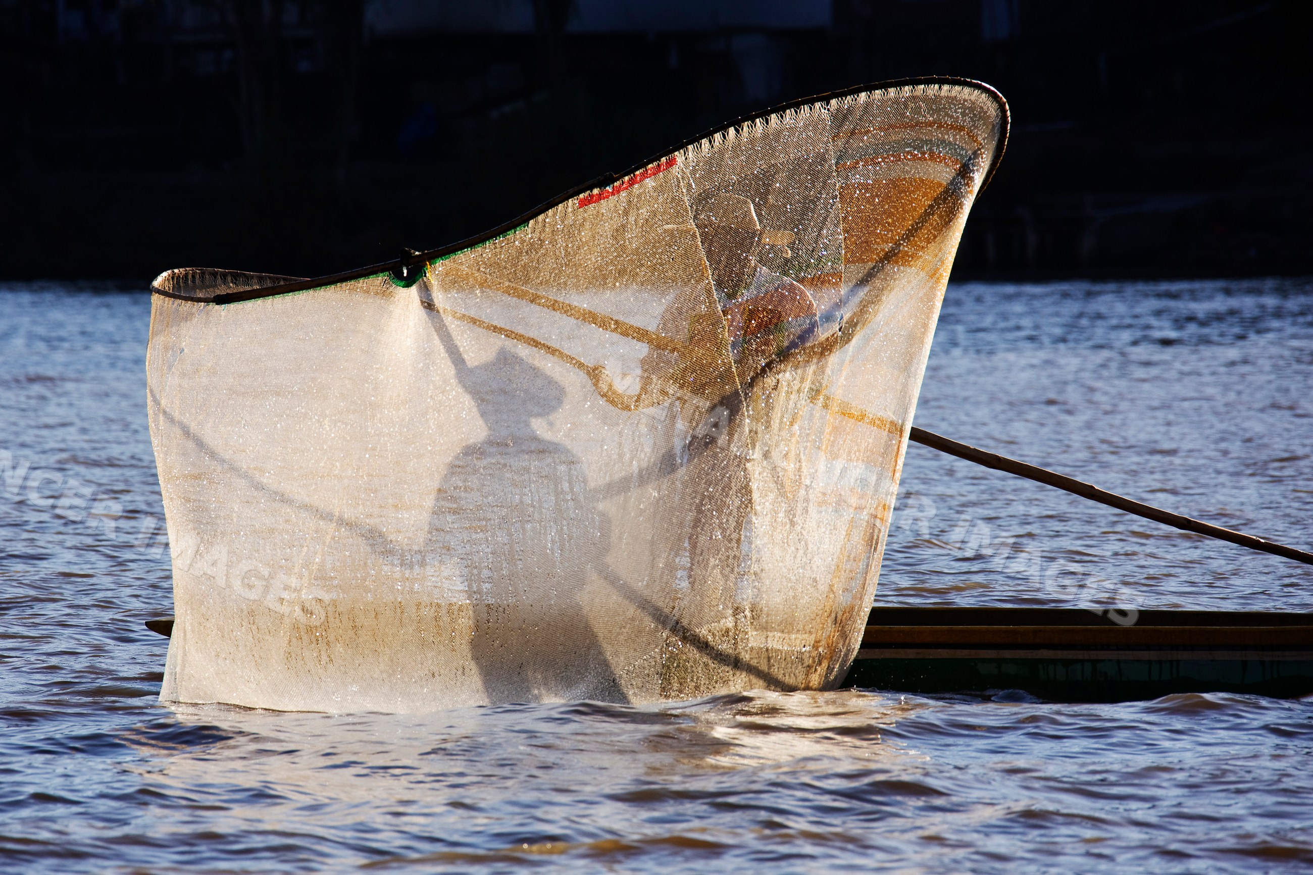 Fishermen casting net on lake mexico