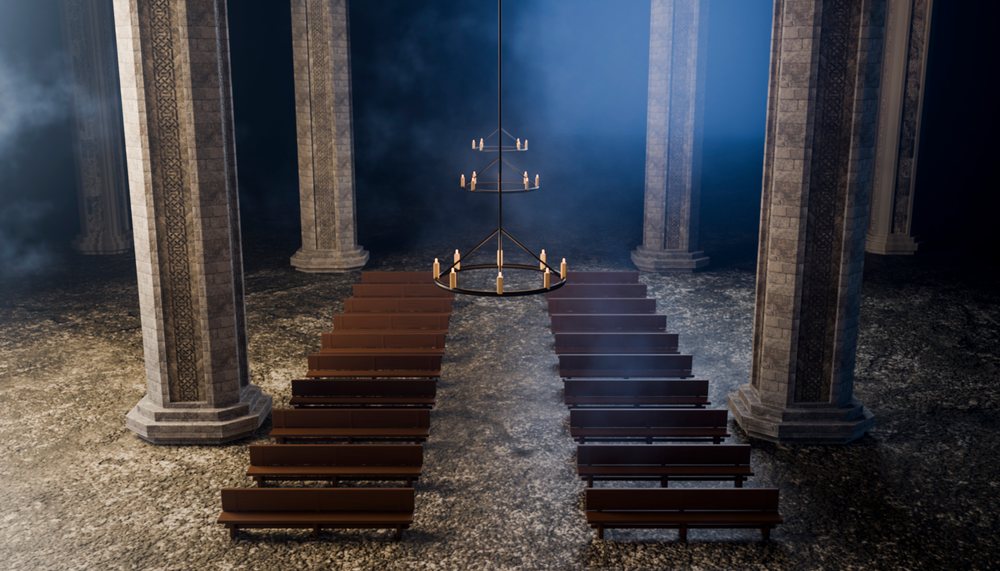 Cathedral interior with stone columns and wooden pews under candle
