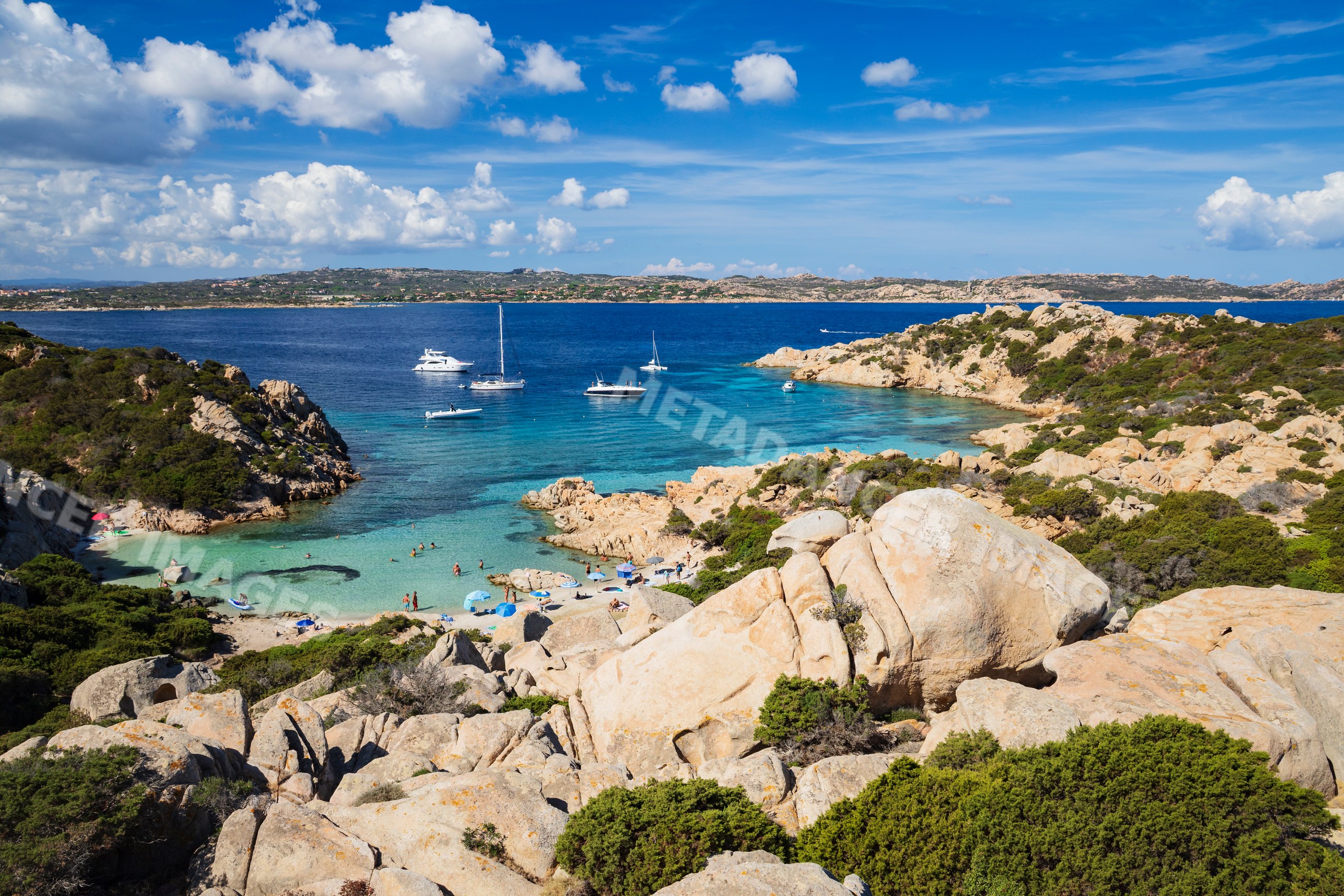 Cala Napoletana with boats and swimmers on a rocky coast