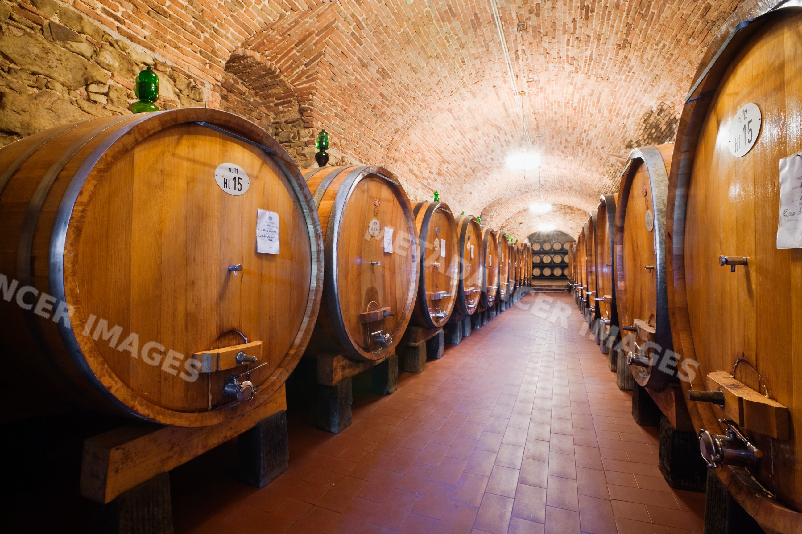 Wooden wine barrels aging in historic vignamaggio cellar tuscany