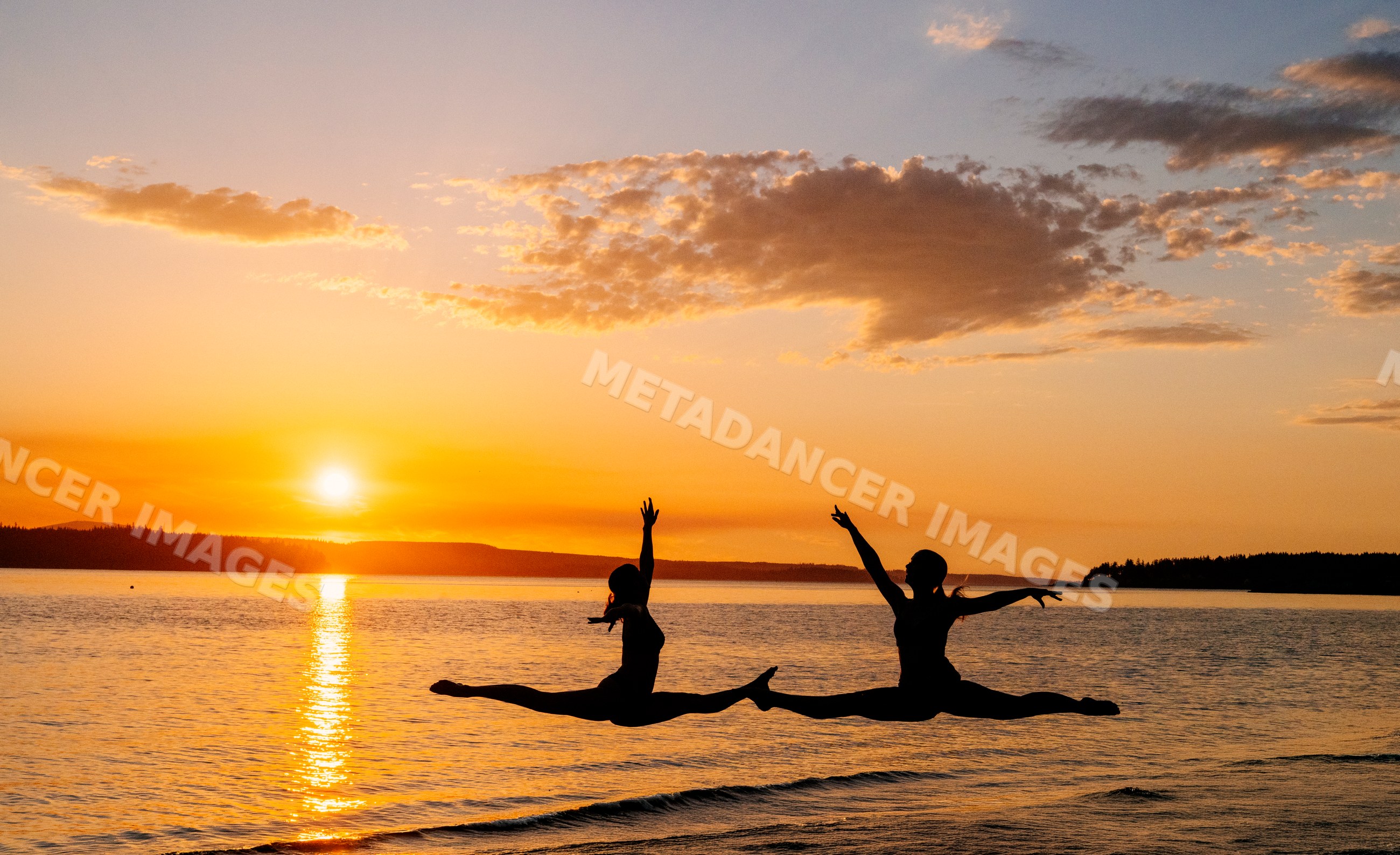 Two white people performing yoga partner acrobatics leaps