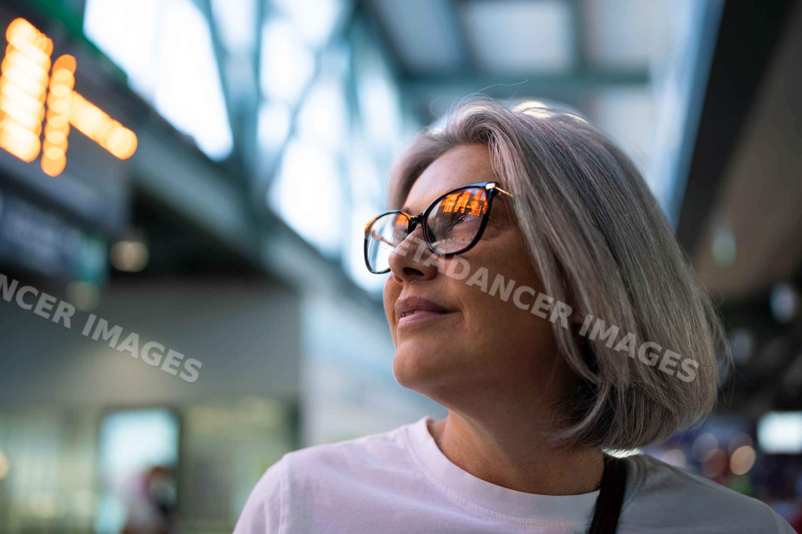 White woman with gray hair wearing eyeglasses indoors