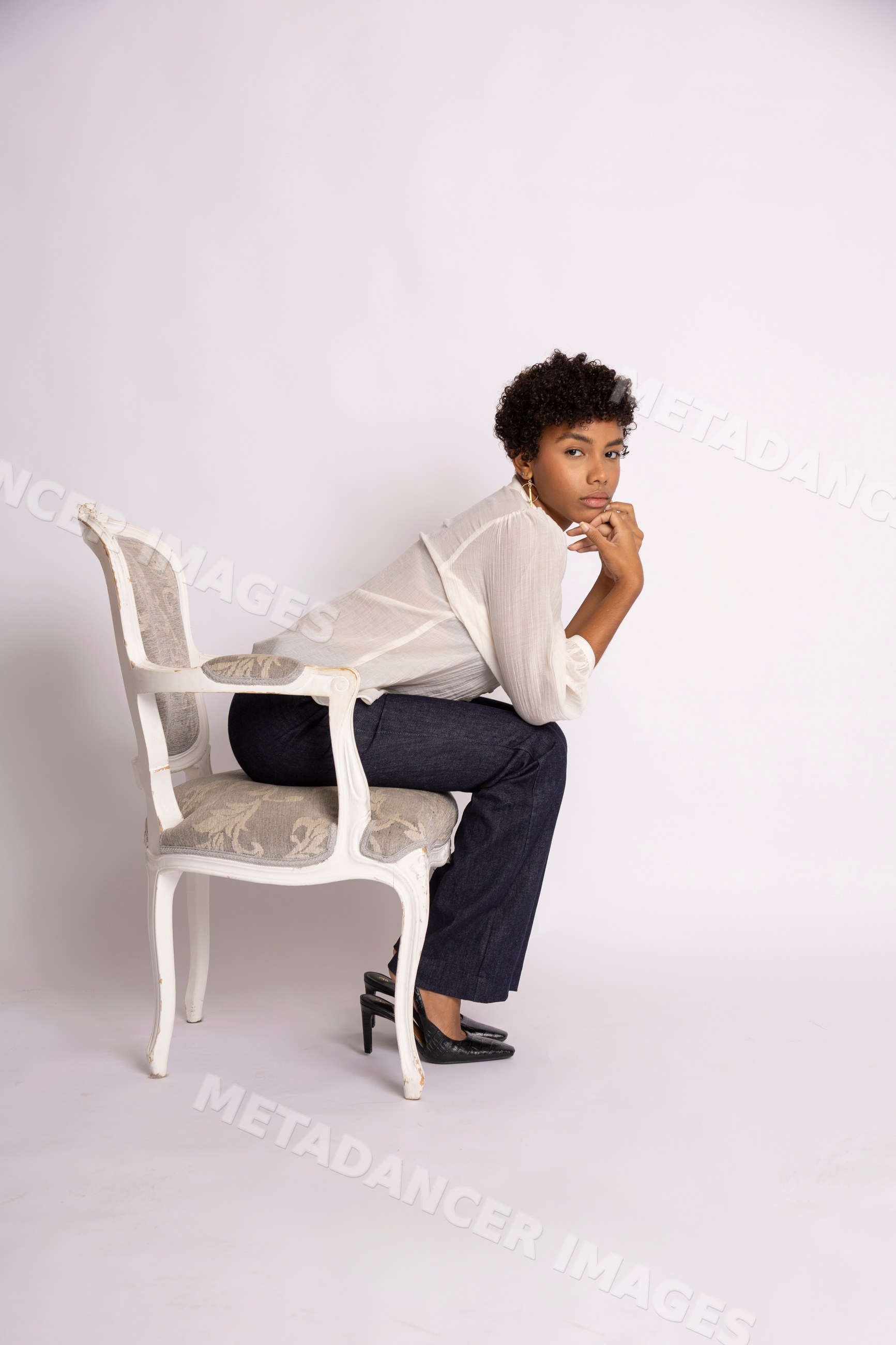 Hispanic woman sitting thoughtfully on antique chair