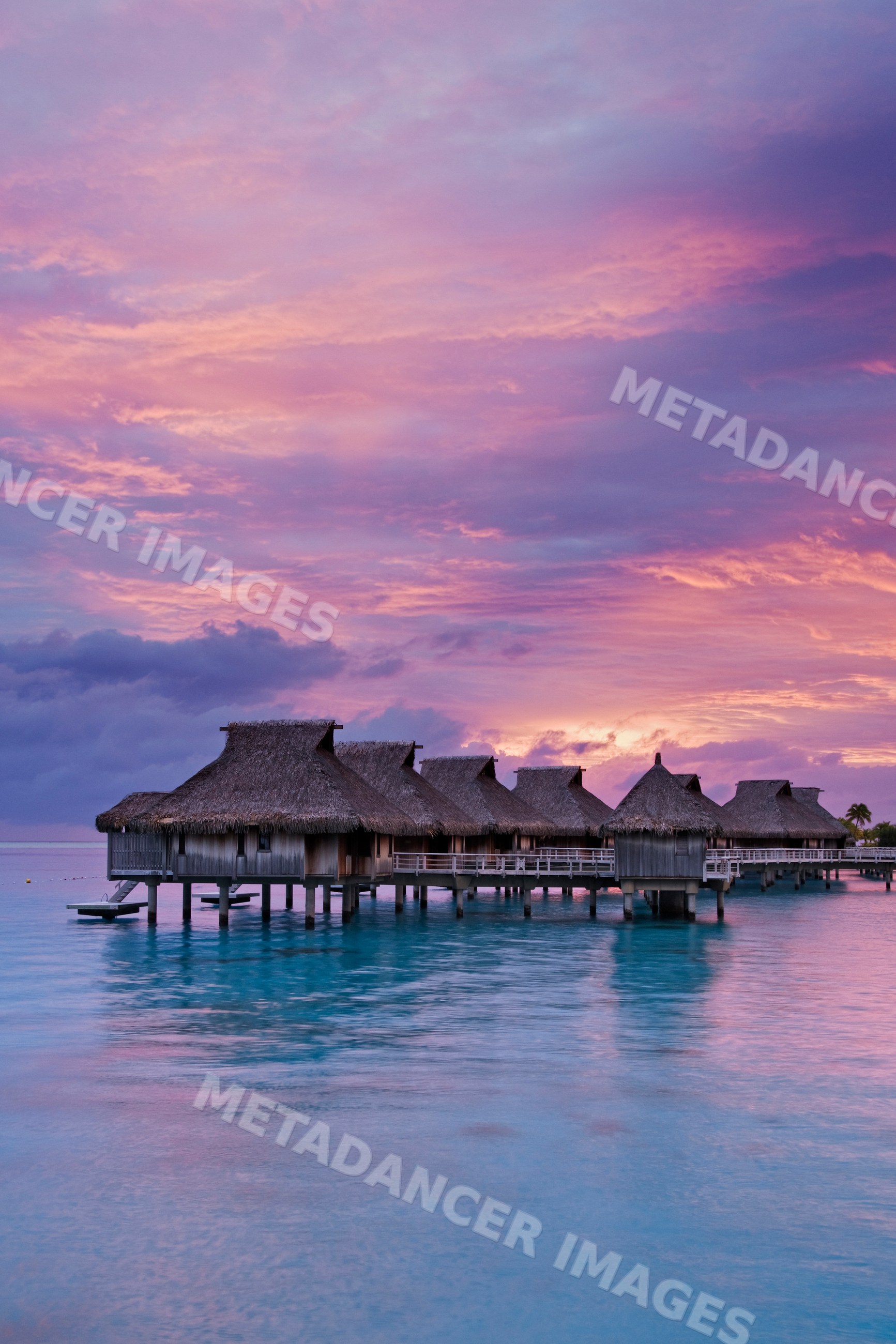 Overwater bungalows with thatched roofs