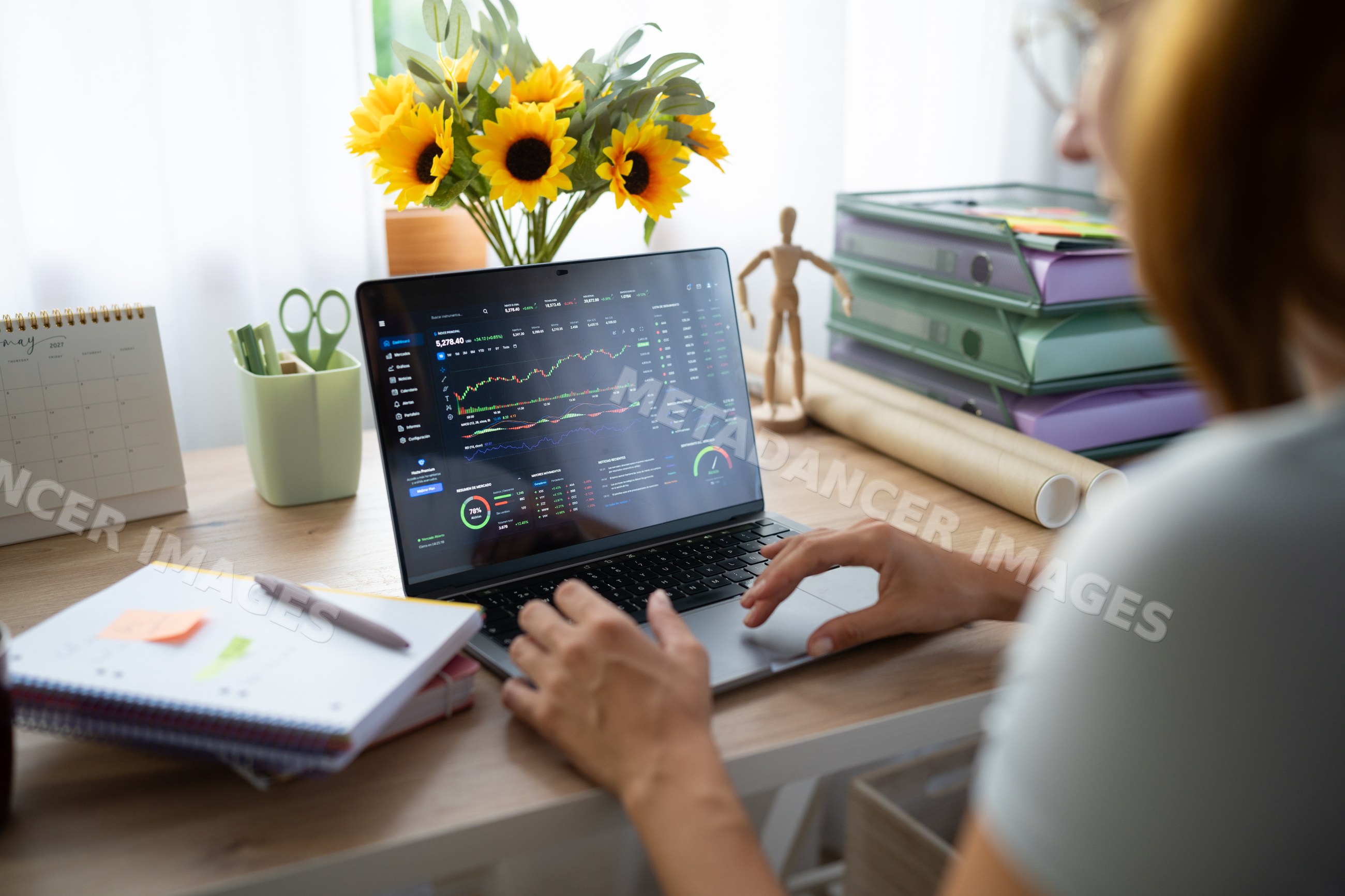 White Person analyzes financial data on laptop in home office in Spain