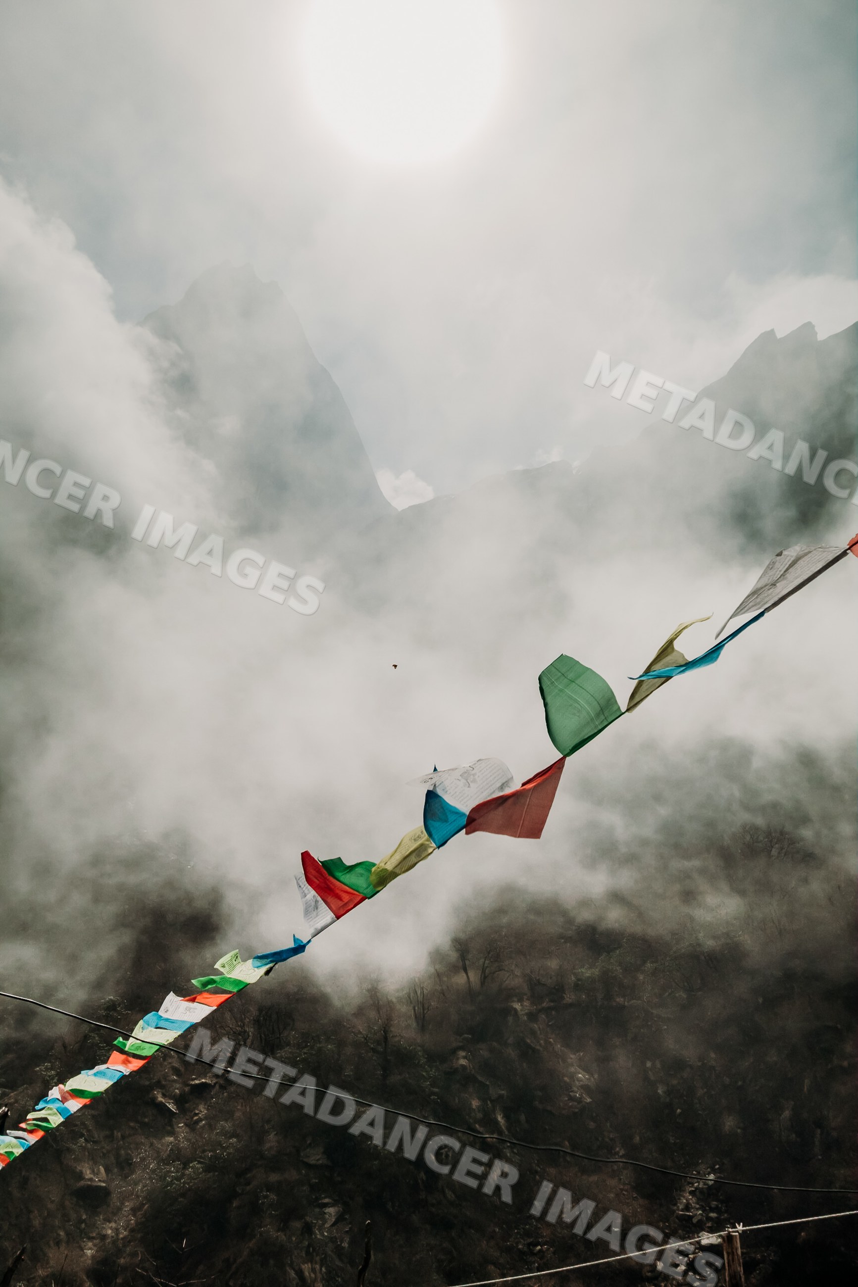 Prayer flags fluttering over misty rocky mountains