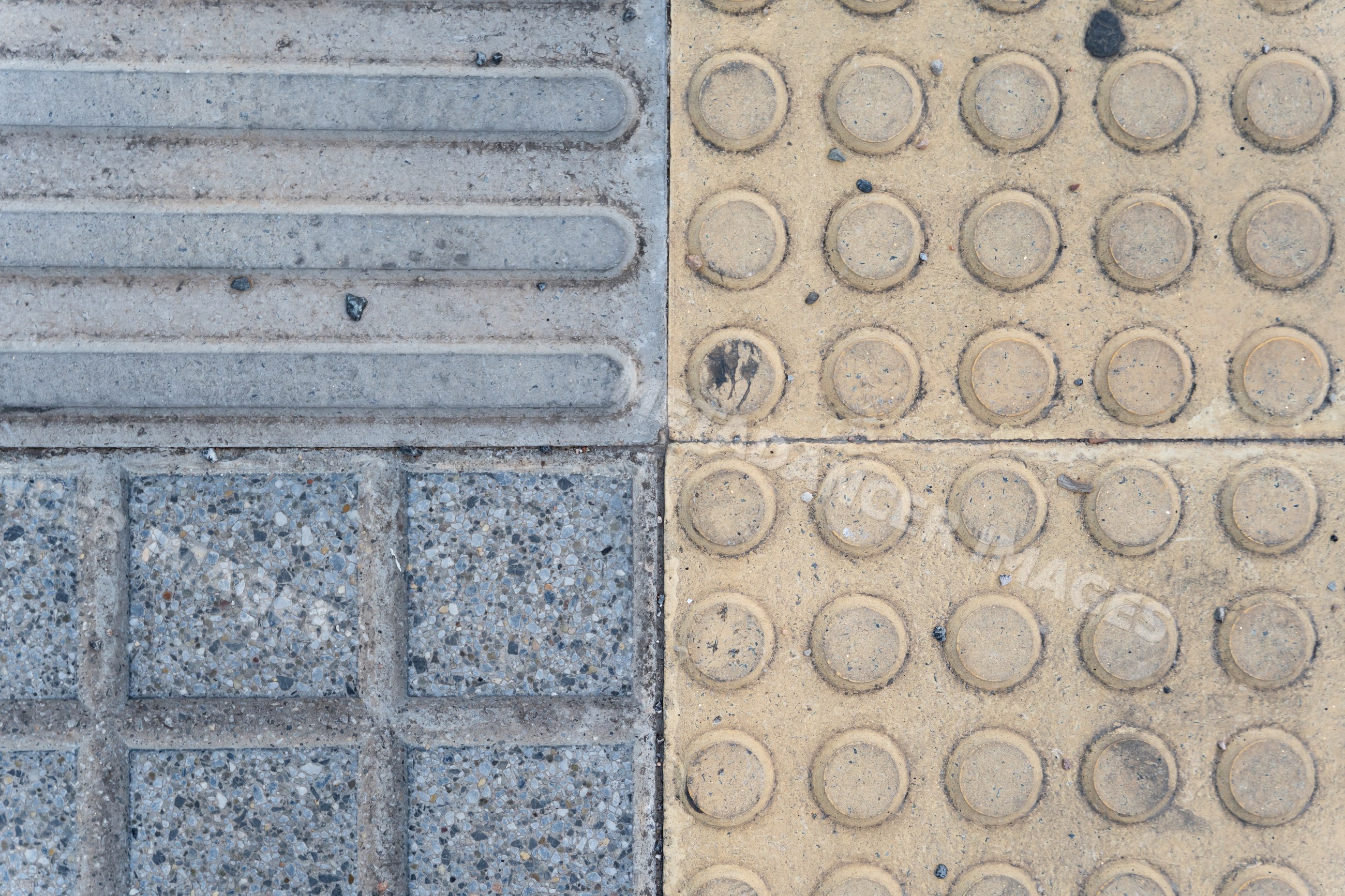 Tactile paving with yellow and gray concrete tiles on urban pedestrian