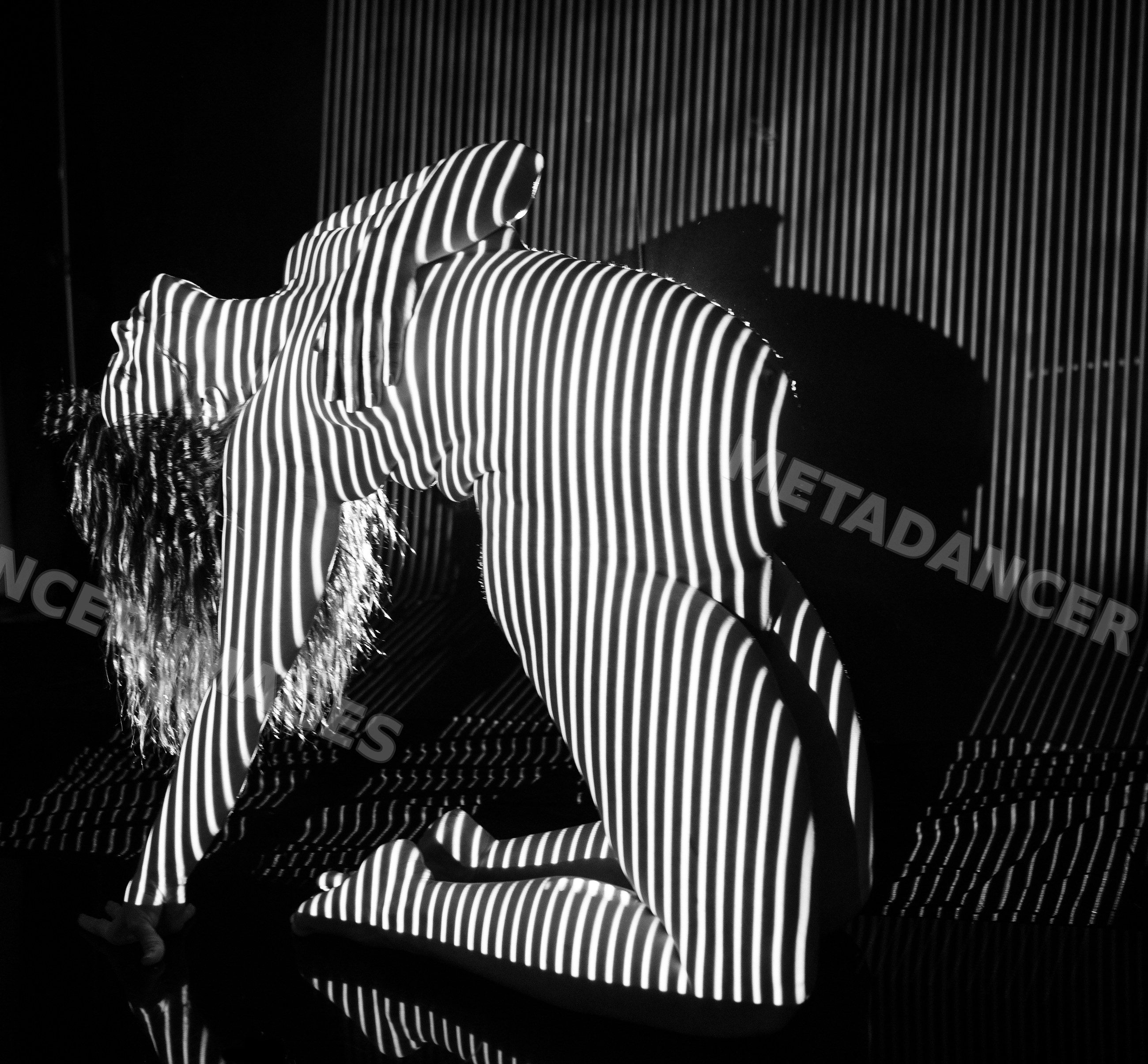 Pregnant woman in black and white striped light projection