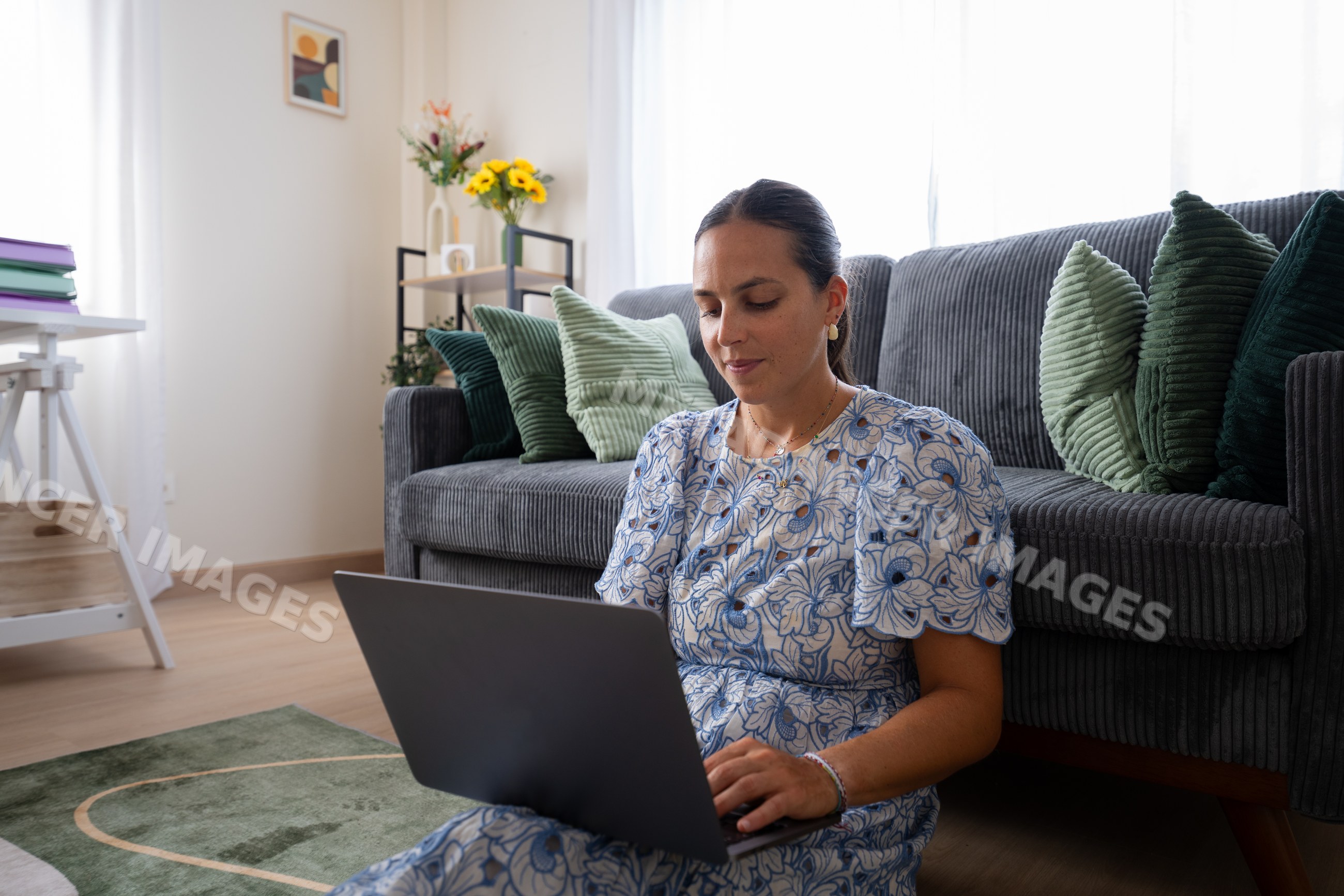 White woman working on laptop in living room in Spain