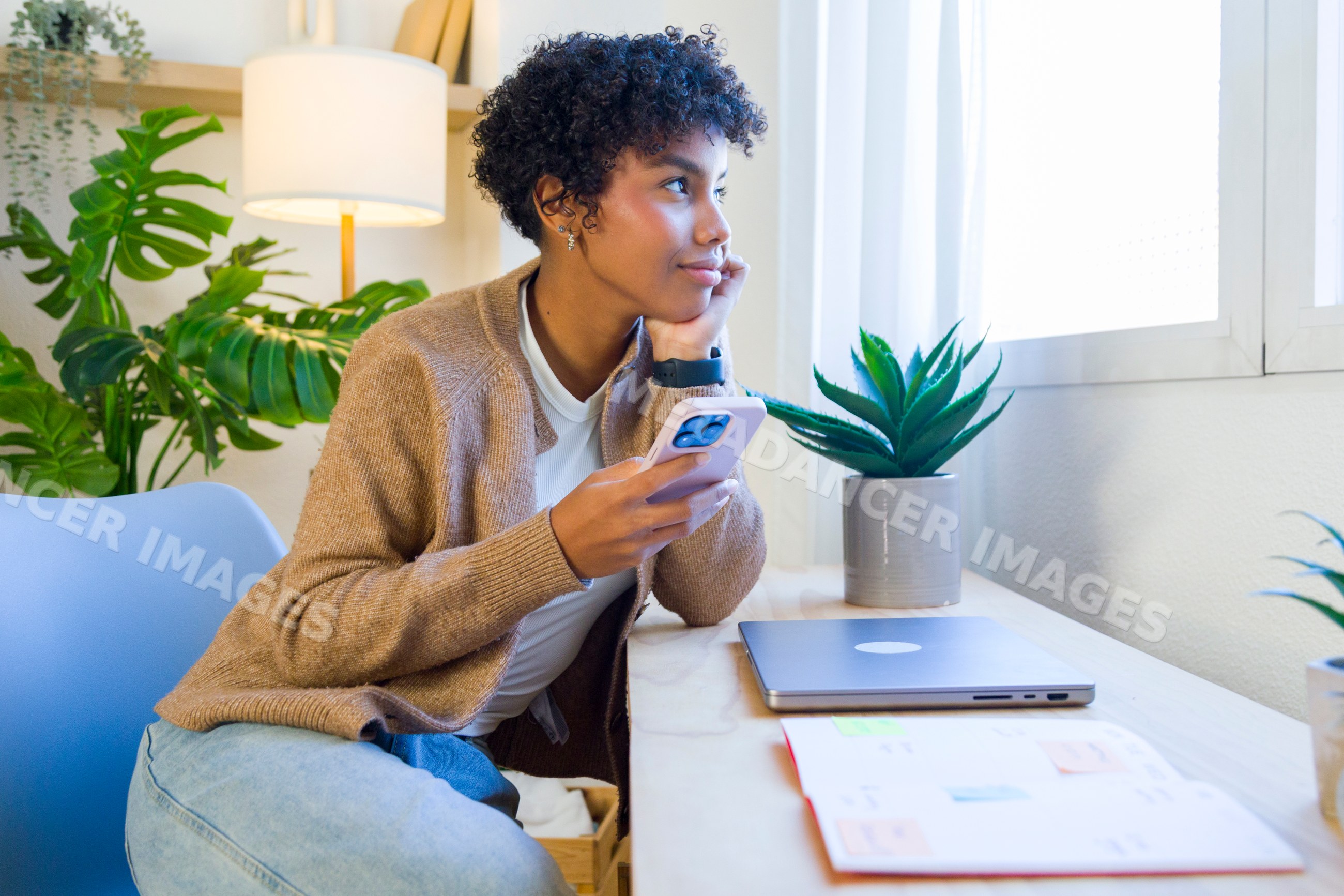 African American woman holding smartphone sitting