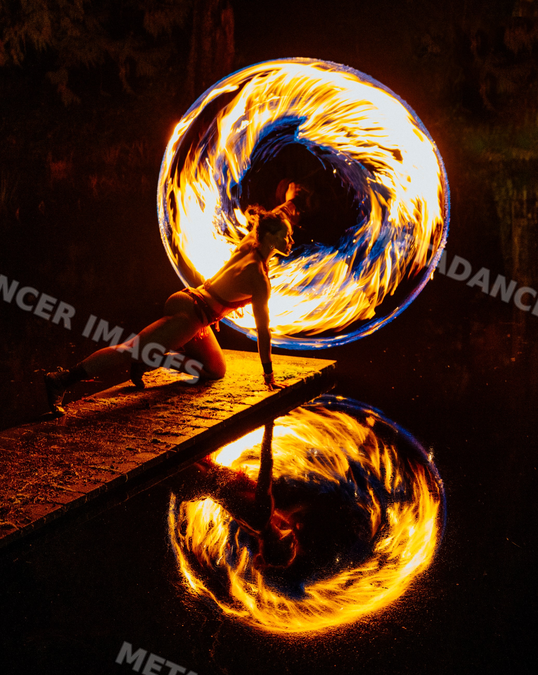 Fire African American dancer spinning flames on pier reflected