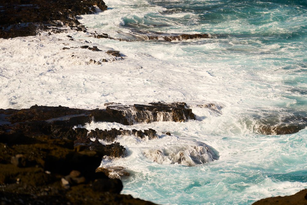 Ocean waves crashing on rocky shore, Hawaii
