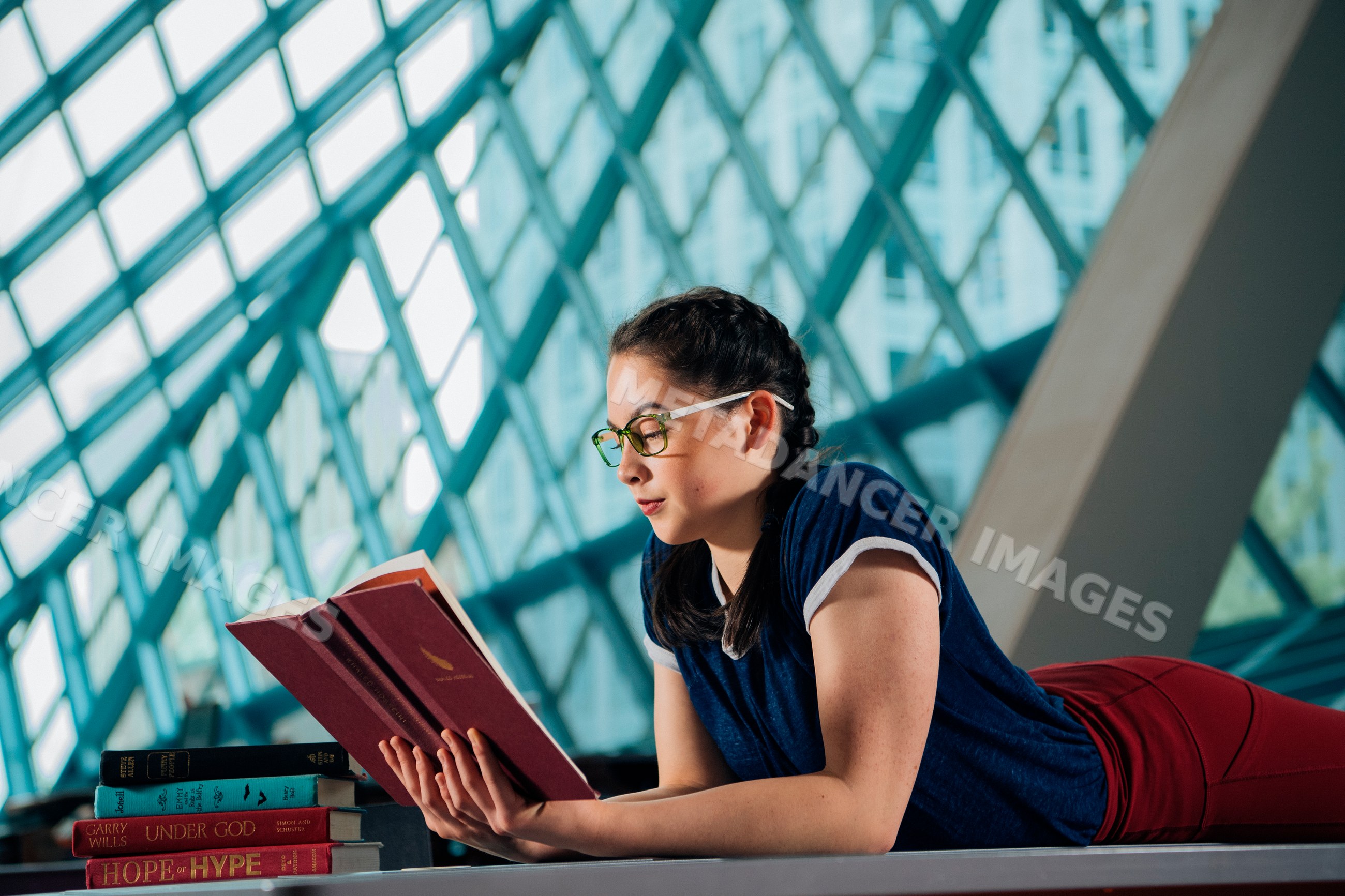 Young woman reading books in a public library in a library