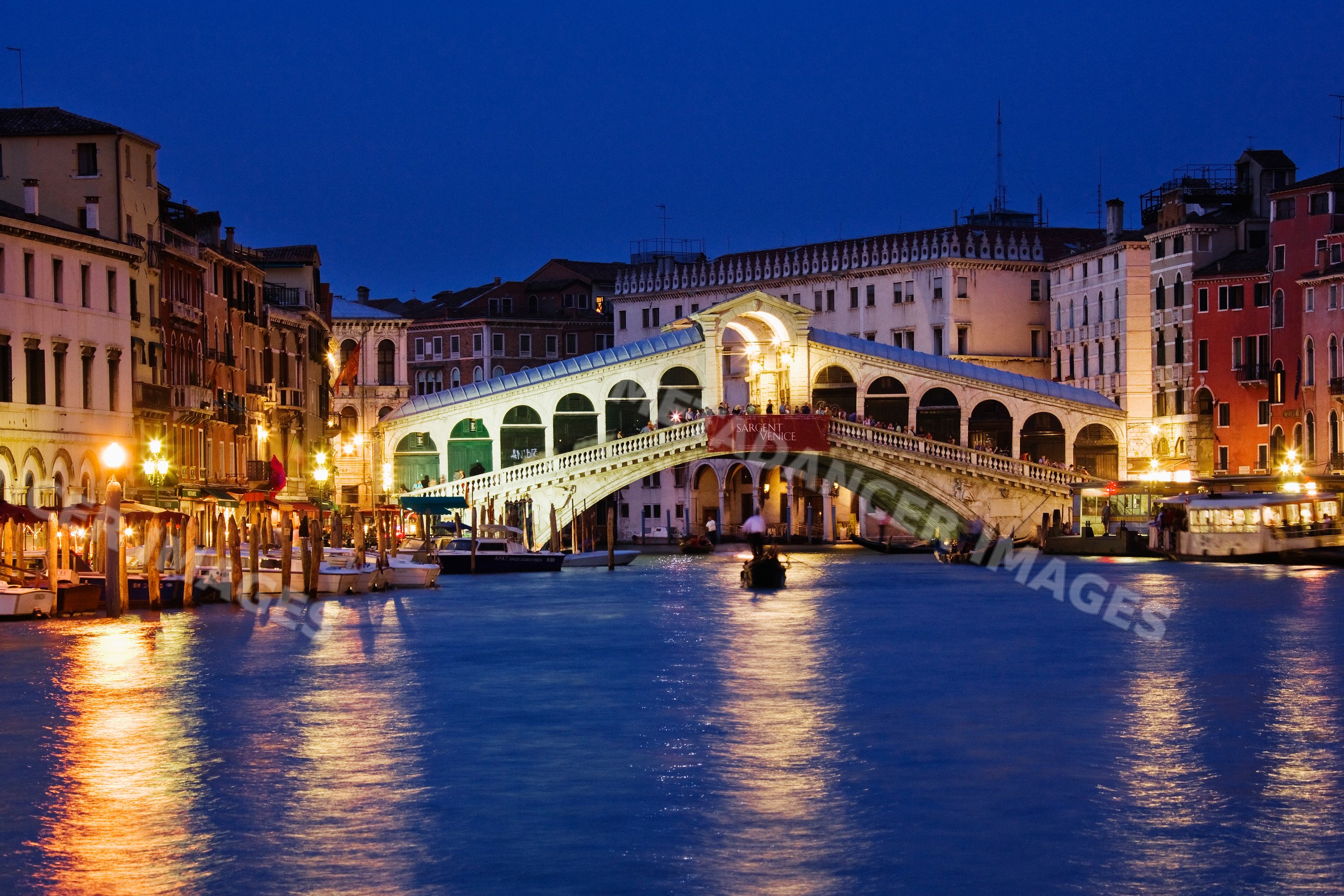 Rialto bridge over canal illuminated at night