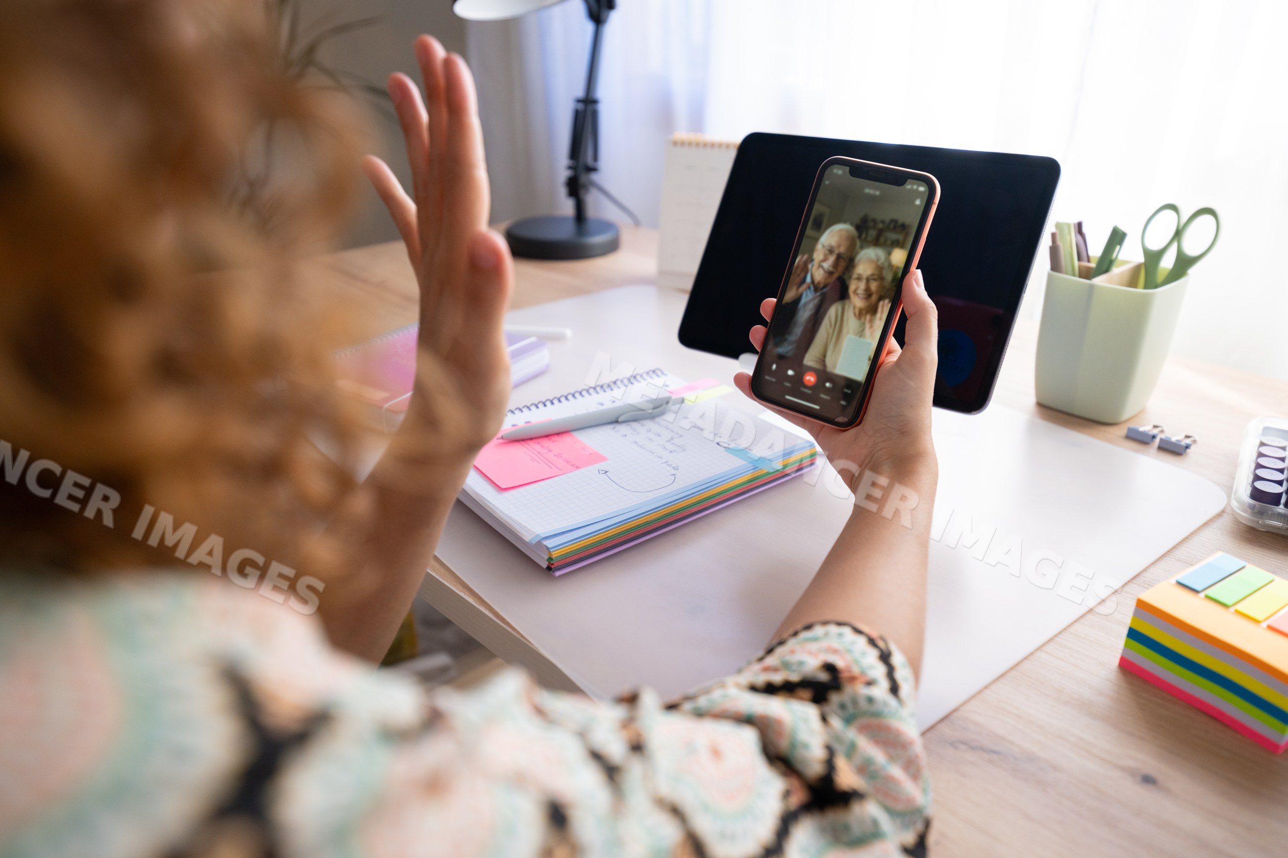 White woman video calling elderly couple