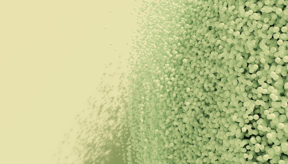 3d rendering of densely packed green spheres with scattered particles